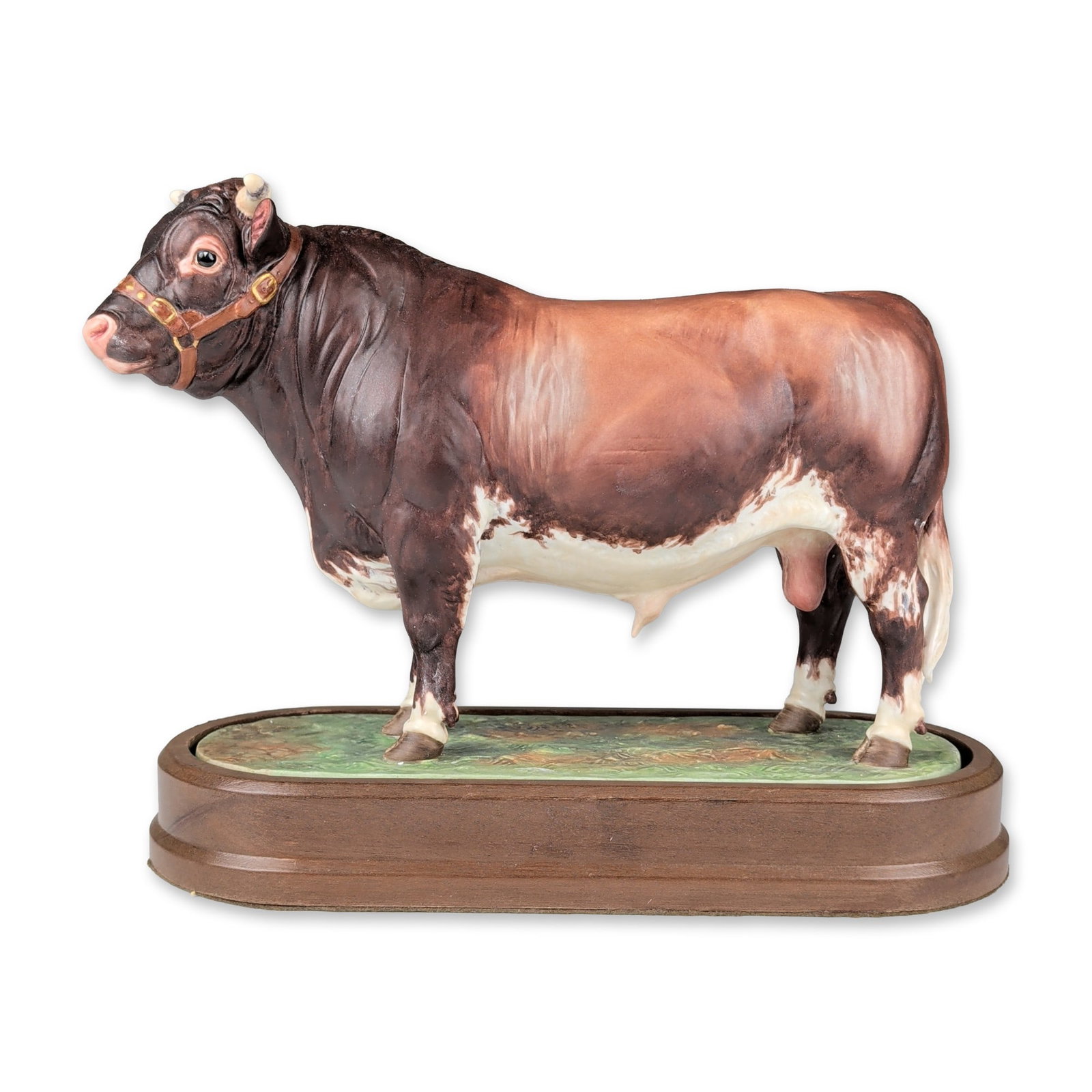 Royal Worcester by Doris Lindner Bone China Figurine with Base, Dairy Shorthorn Bull: The figure is realistically modeled with a roan-colored coat in deep brown and white, featuring a painted harness with gold-tone hardware. The bull stands on an integral oval porcelain base with a tex