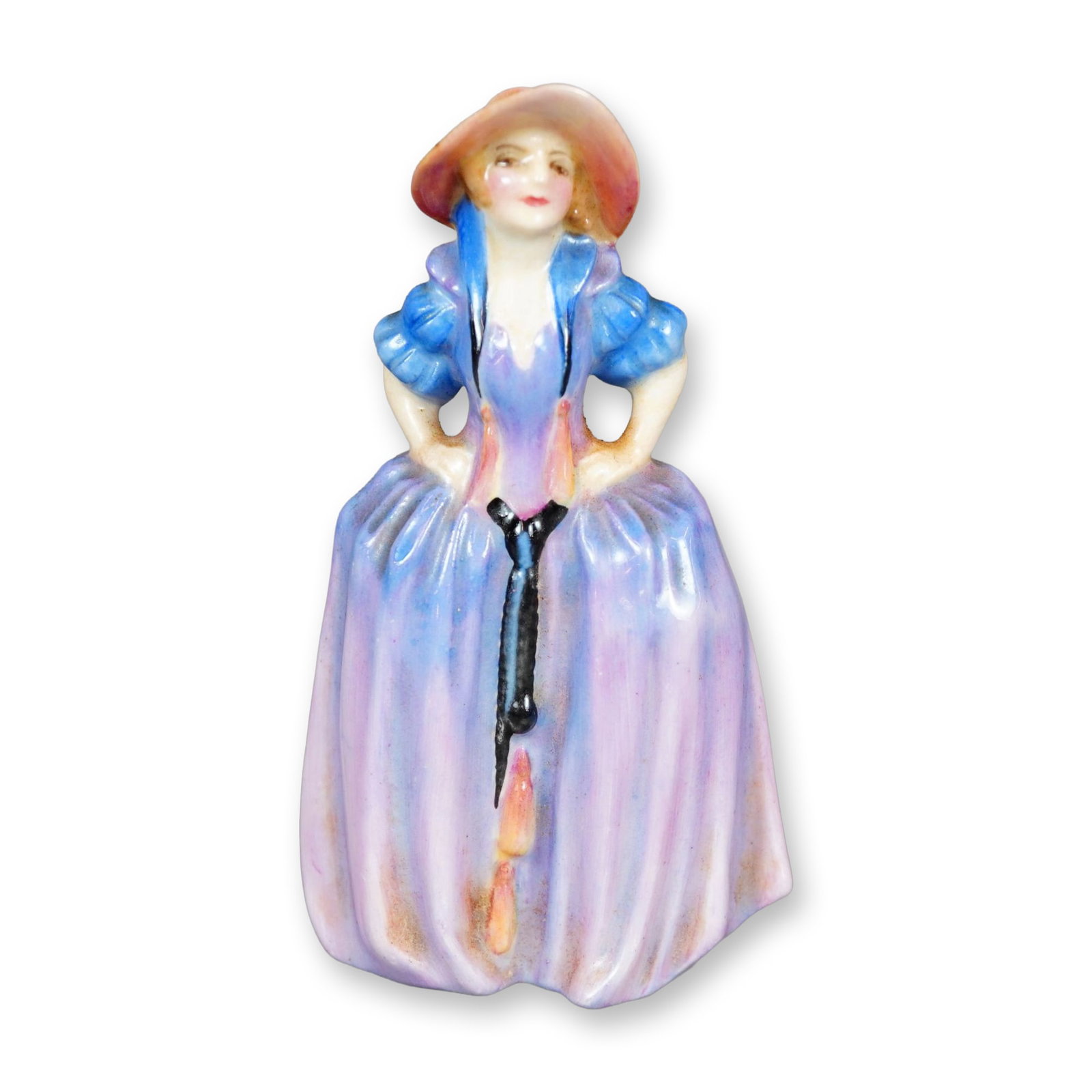 Royal Doulton Bone China Figurine, Patricia M28: Hand painted figure of a young woman in a purple-pink gown accent with pink hat. She is shown with her hands on her hips. Royal Doulton backstamp. Dimensions: 2.25"L x 1.75"W x 4"H Manufacturer or Bra