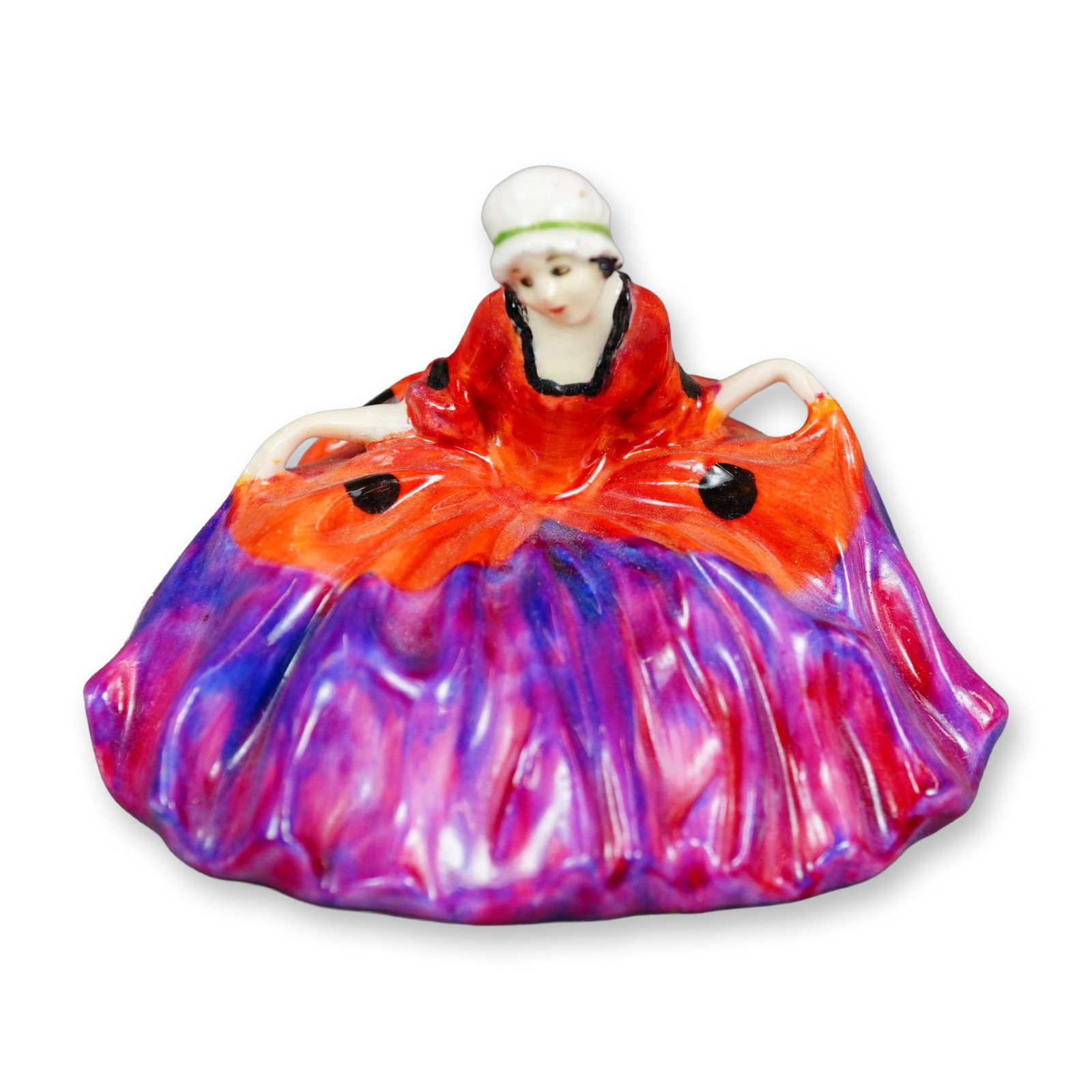 Royal Doulton Colorway Figurine, Polly Peachum: Character from "The Beggar's Opera", the figure depicts a young woman curtsying. She is shown wearing red and purple gown with black spots. Royal Doulton backstamp. Dimensions: 3"L x 2.5"W x 2.25"H Ma