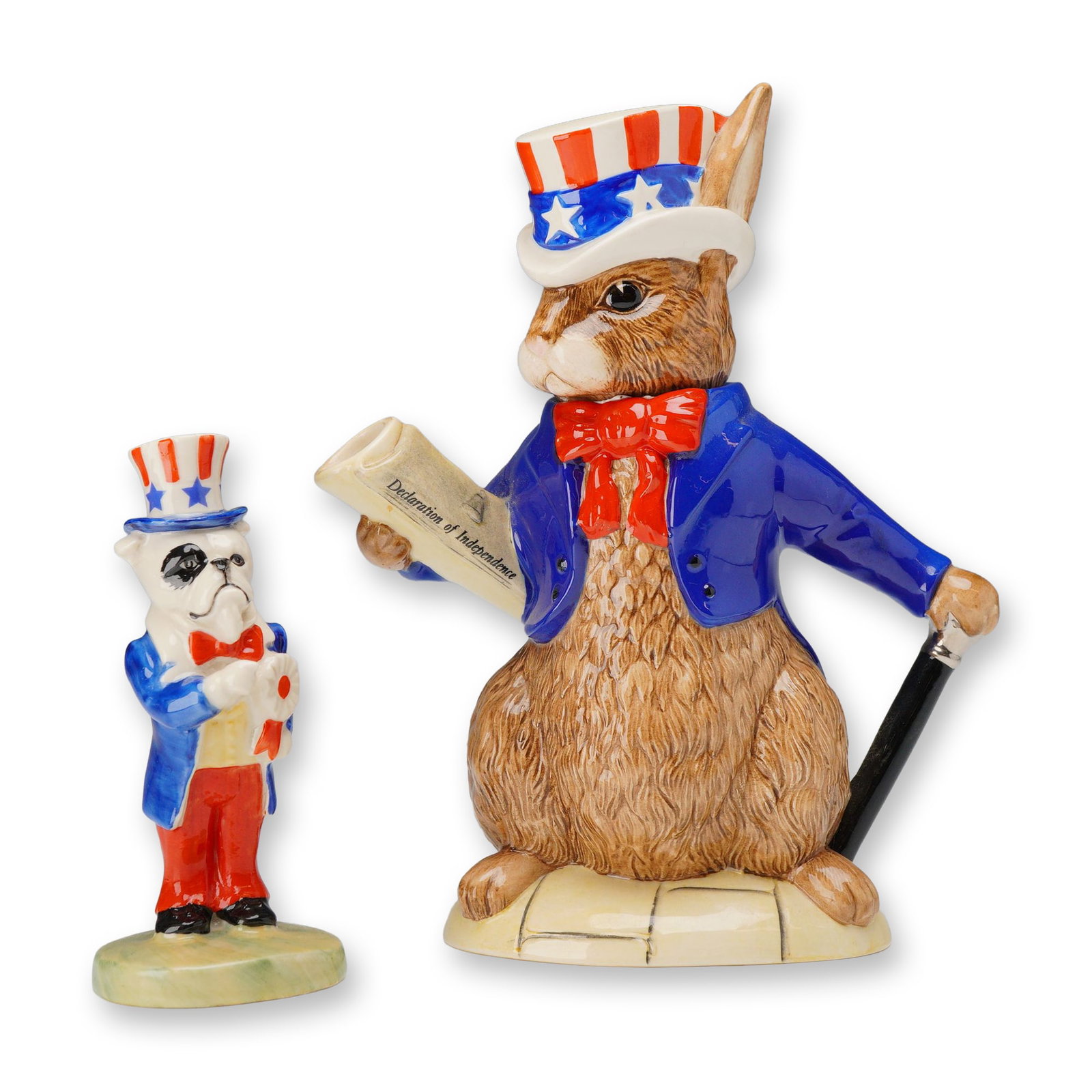 2pc Royal Doulton Bunnykins U.S.A. President Teapot, and Peggy Davies Bulldog Uncle Sam Figurine: Two patriotic-themed glazed ceramic pieces, including one Royal Doulton Bunnykins character teapot and one Peggy Davies bulldog figurine. The Bunnykins teapot, titled U.S.A. President (D 6996), depict