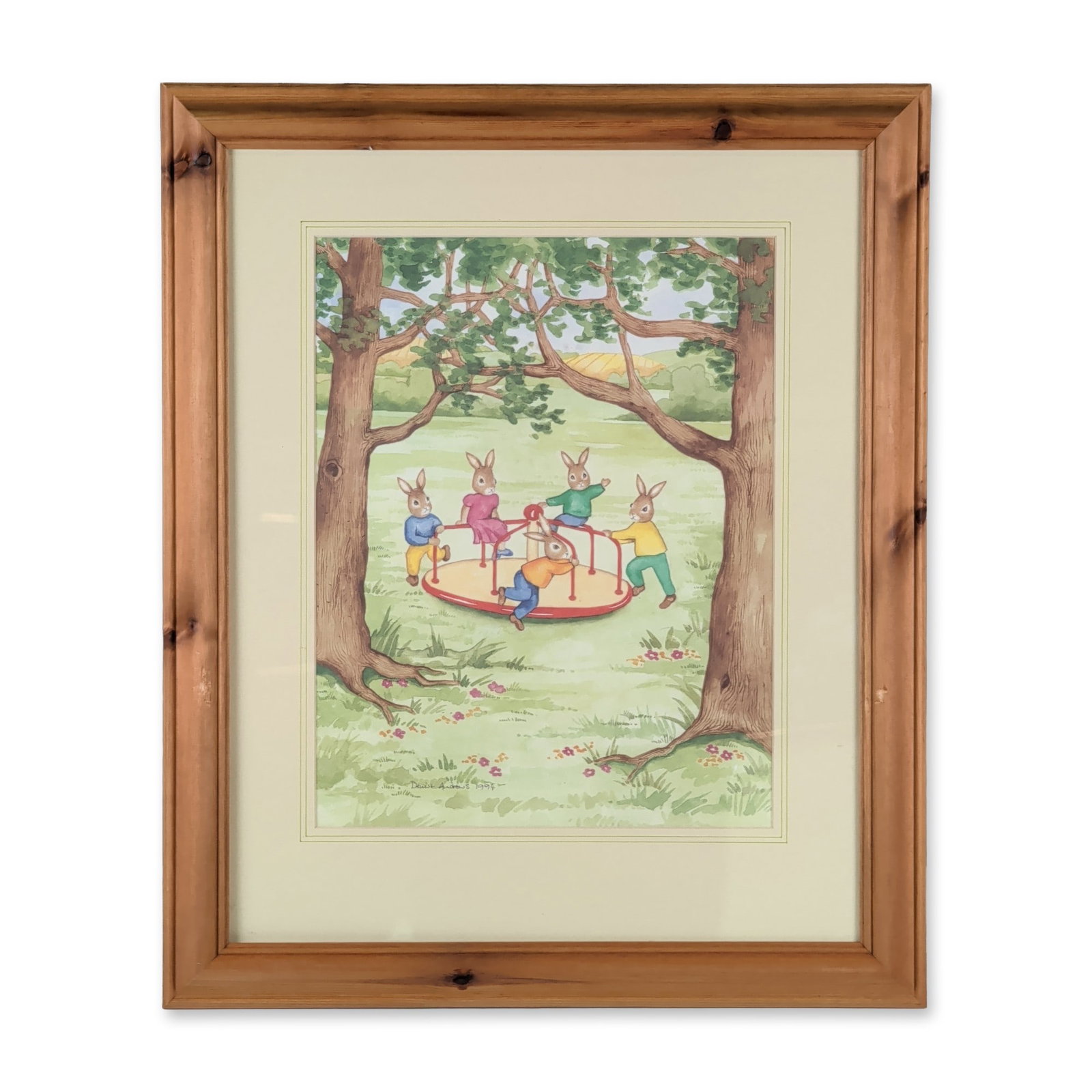 Denise Andrews 1994 Framed Original Watercolor Bunnykins Painting, The Playground Roundabout: Housed in a wooden frame with a cream-colored mat, an illustration in watercolor and gouache on paper, depicting five children Bunnykins in colorful attire playing on a red and yellow roundabout in a 