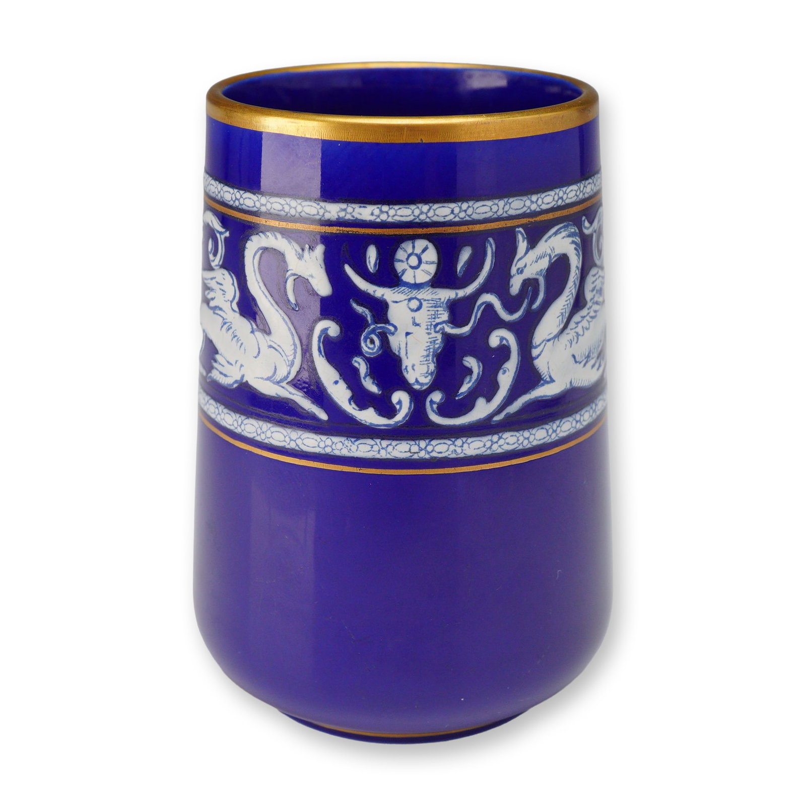 Wedgwood Cobalt Blue Gilded Vase with Dragon Motif, c. 1871: A Wedgwood dark blue vase or beaker, dated circa 1871. The cylindrical body is finished in a deep cobalt blue glaze featuring a central white bas-relief decorative band of neoclassical motifs. One sid