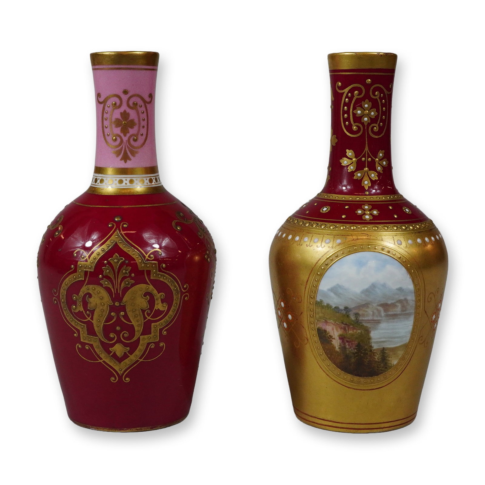 2pc Wedgwood Porcelain Small Gilded Vases: The vases are designed in an ovoid bottle form with slender, slightly flared necks. The first vase is finished with a ruby-red ground on the body and a pink ground on the neck, featuring intricate rai