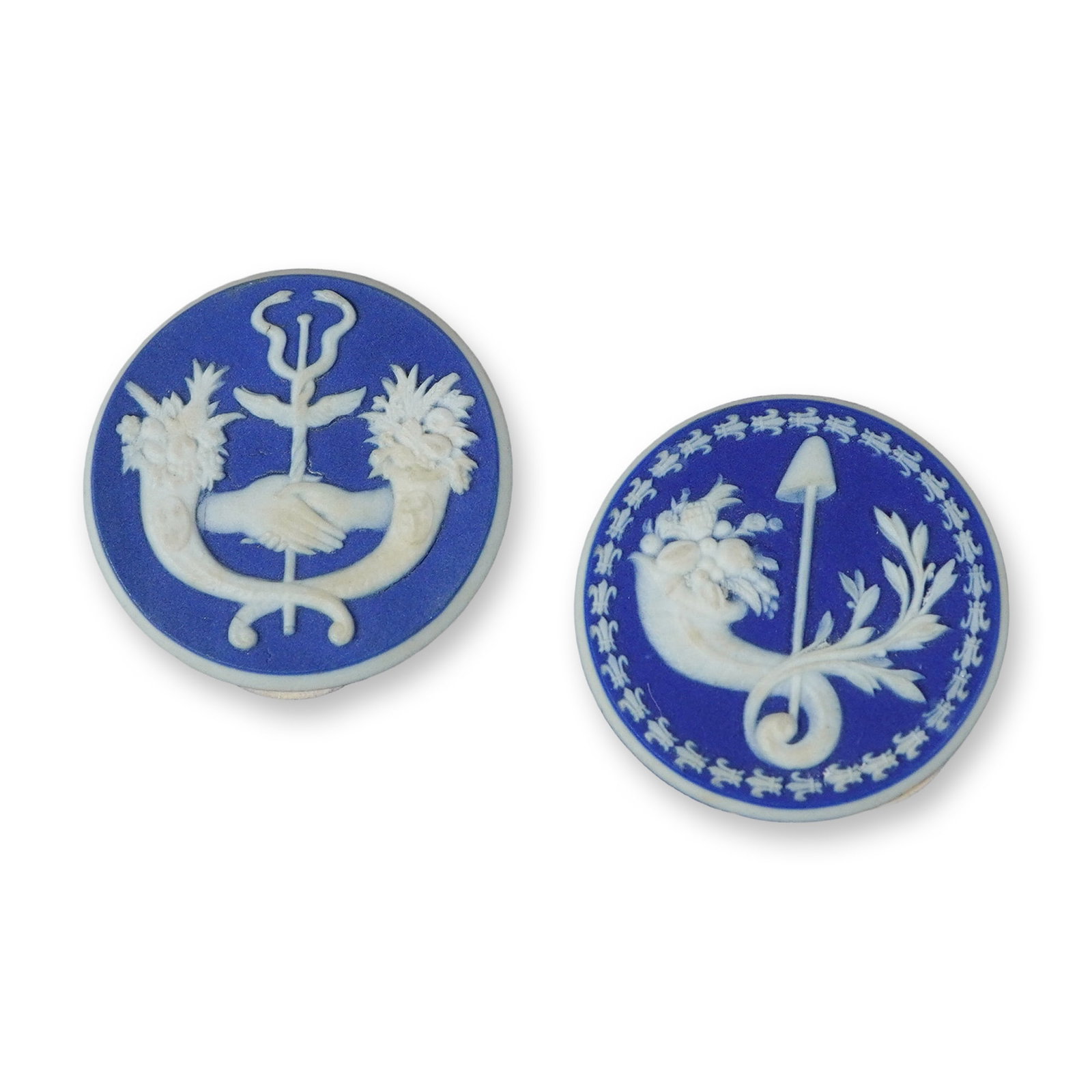 2pc Wedgwood Blue Jasperware Symbolic Medallions: This pair of circular medallions is manufactured in blue jasperware by the Wedgwood factory in England. Each piece features white bas-relief sprigged ornamentation on a blue jasper dip ground. The fir