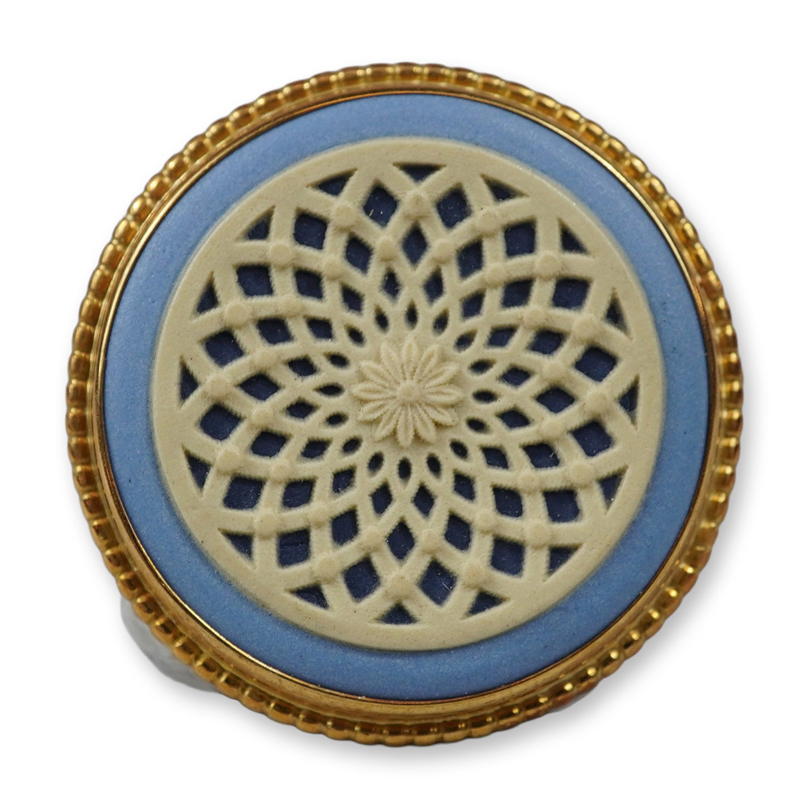 Wedgwood Blue and White Jasperware 18K Gold Brooch: This circular brooch is manufactured by Wedgwood in England. It features a blue jasperware ceramic base decorated with an intricate, openwork white relief in a geometric engine-turned pattern, accente