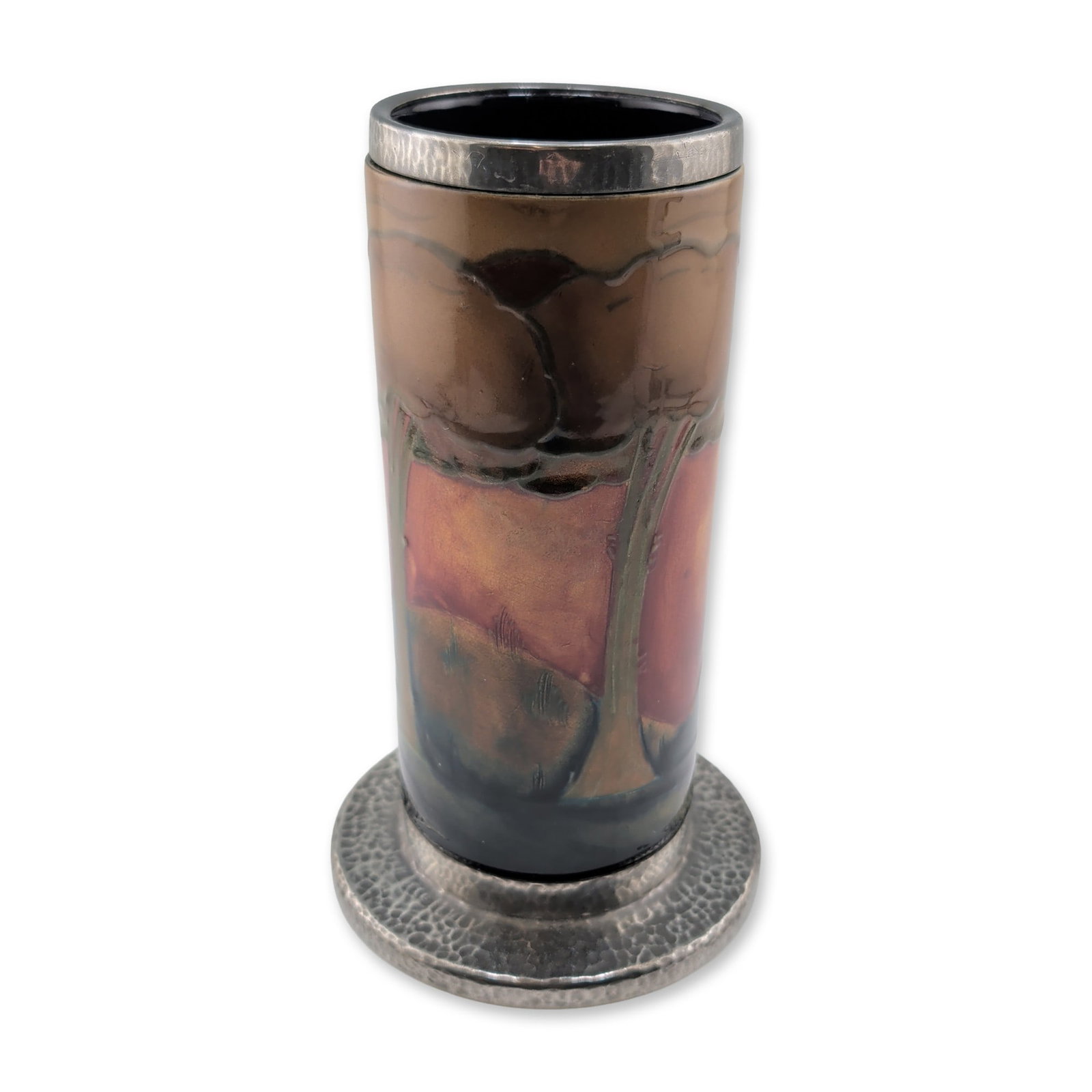 Moorcroft Pottery and Pewter Tudric Mounted Vase, Eventide: Eventide pattern vase in glazed earthenware with Tudric hammered pewter mounts. The cylindrical ceramic body is decorated with a landscape of stylized tree forms in ochre, deep red, and dark blue glaz