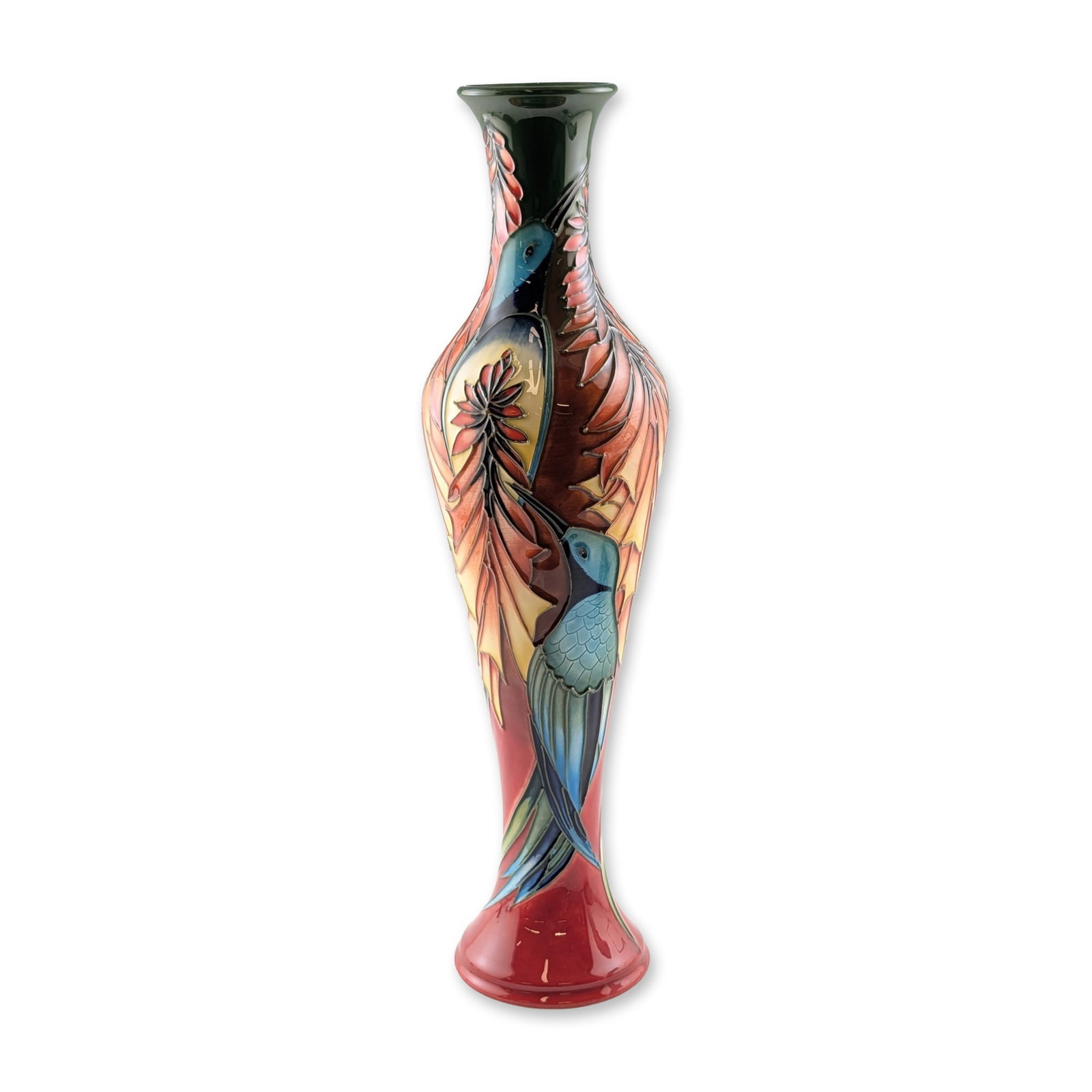 Moorcroft Pottery by Philip Gibson Hummingbird Vase: Limited edition. This slender earthenware vessel features tube-lined decoration depicting two hummingbirds in shades of blue and teal set against stylized botanical leaves. The color palette incorpora