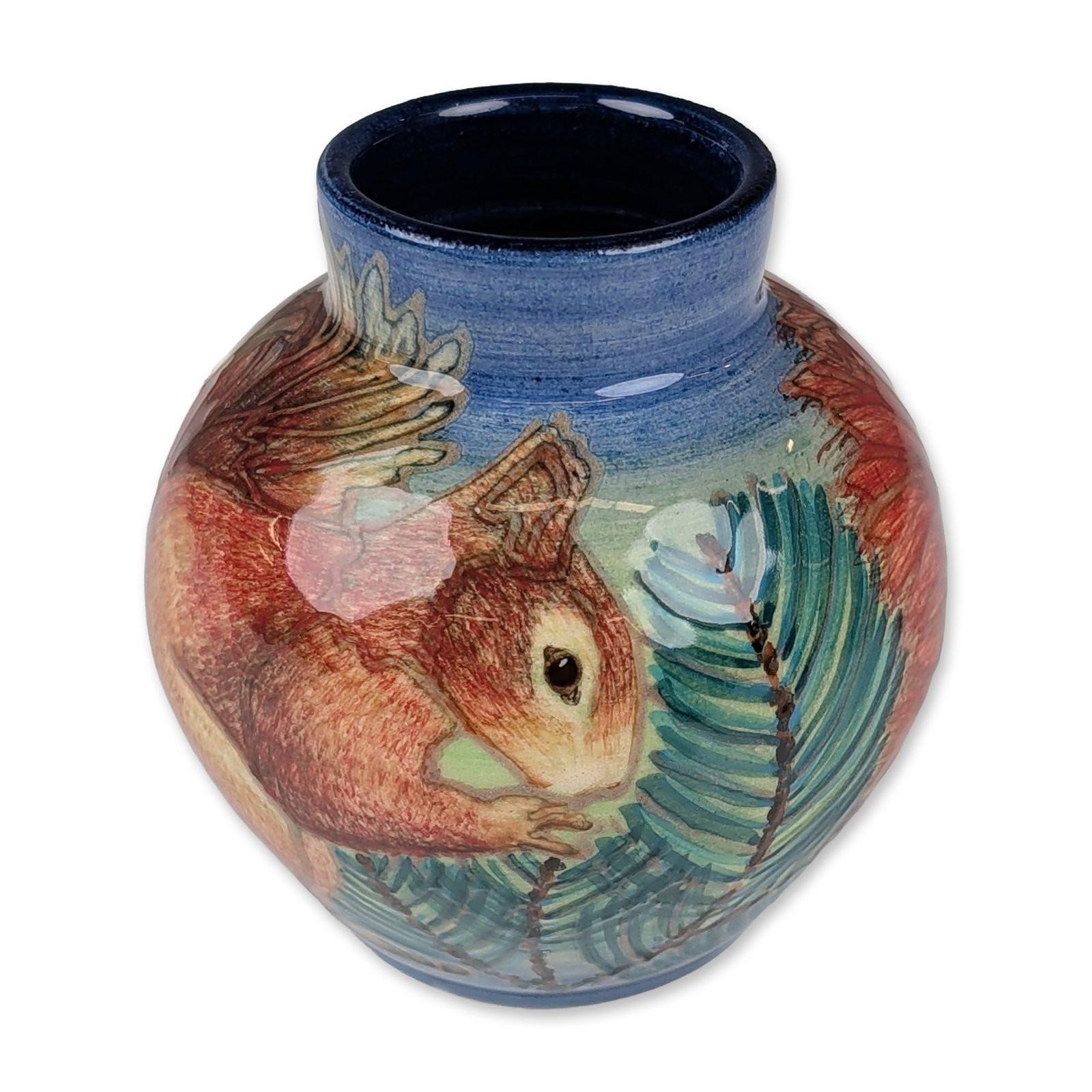Dennis Chinaworks for Dorset Wildlife Trust by Sally Tuffin Pottery Red Squirrel Vase: A small globular vase featuring a detailed hand-decorated painted design of a red squirrel among evergreen branches. The neck and interior are finished in a deep cobalt blue glaze, contrasting with th