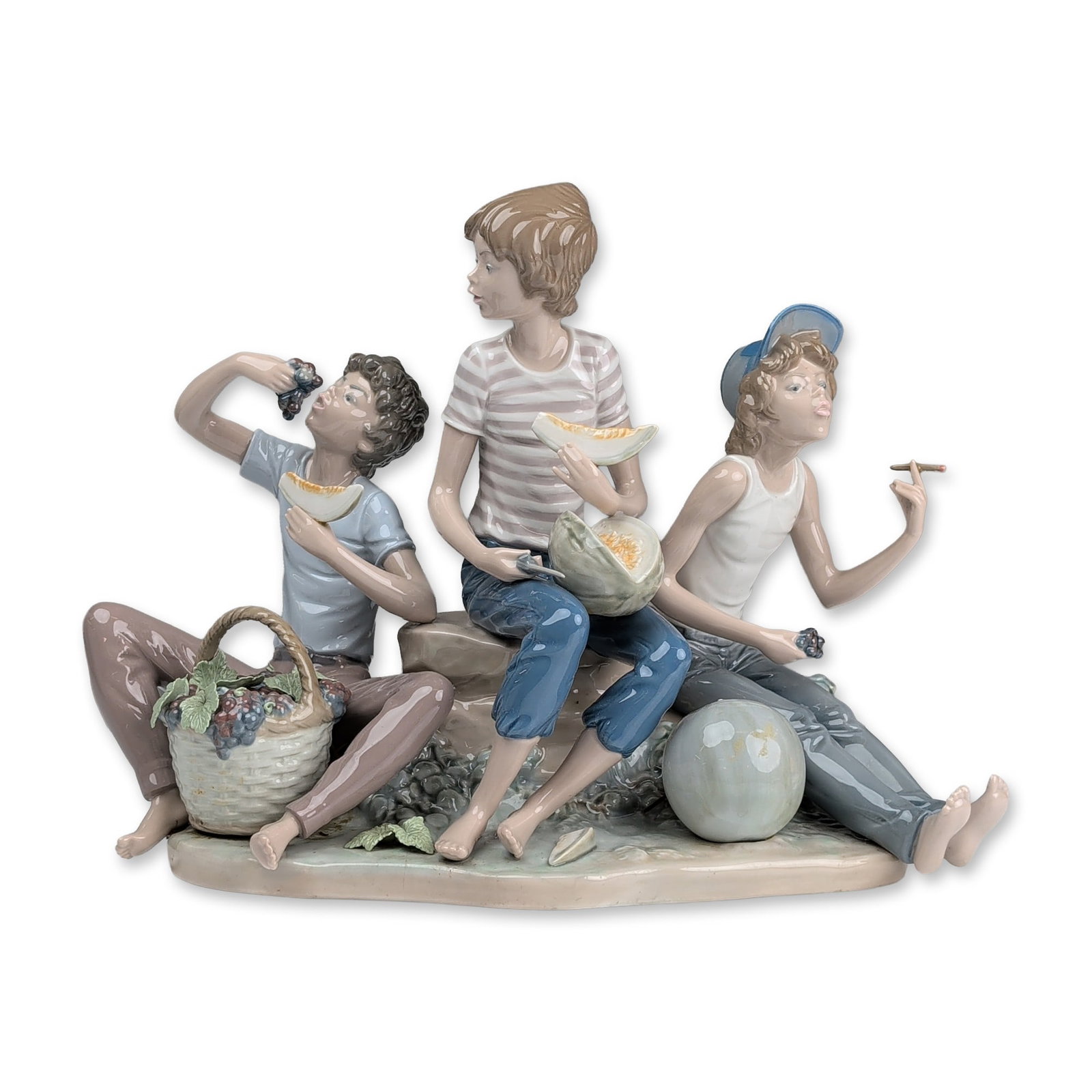 Lladro Porcelain Figural Group, Sweet Harvest 01005380: Porcelain figural group designed by sculptor Jose Roig. The composition depicts three young boys in casual attire seated on a rocky outcrop possibly inspired by the Murillo painting The Melon and Grap