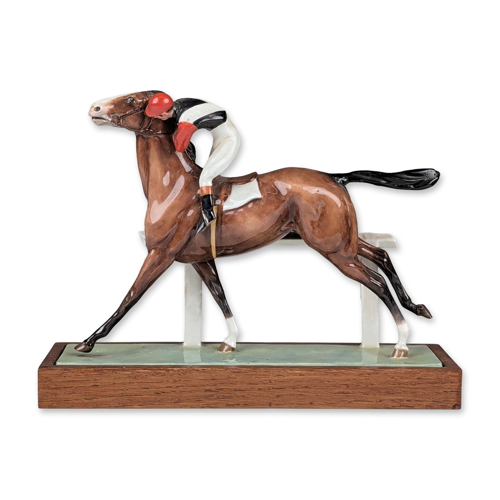 Royal Worcester by Doris Lindner Bone China Figurine, Cantering to the Post 3117: Hand-painted porcelain equestrian figurine depicting a bay horse and jockey beside a white two-rail fence. The horse is modeled in a walking pose with the jockey leaning forward in racing silks compri