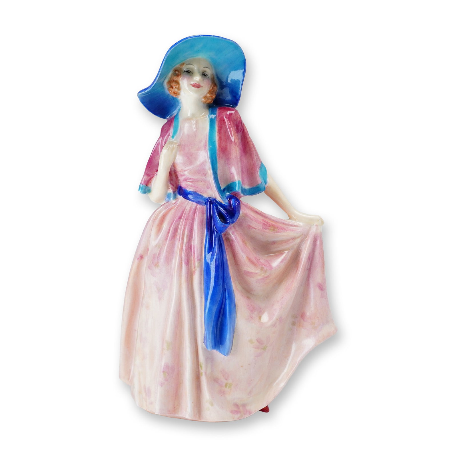 Royal Doulton Bone China Figurine, Nadine HN1886: Part of the Harradine Classics series, designed by Leslie Harradine. This hand-painted figurine depicts a woman wearing a long pink floral dress, accented with a blue hat and a blue ribbon tied at her