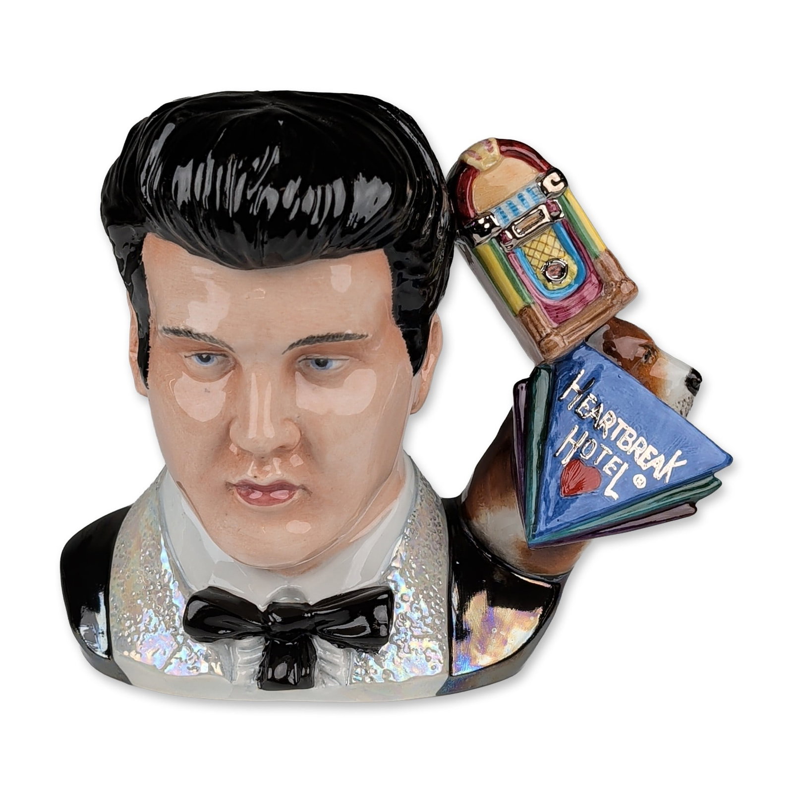 Royal Doulton Prototype Large Character Jug, Elvis Presley: Elvis Presley character jug in glazed ceramic, depicting the entertainer with a black pompadour and sideburns. The figure wears a white tuxedo with an iridescent luster finish on the lapels and shirtf