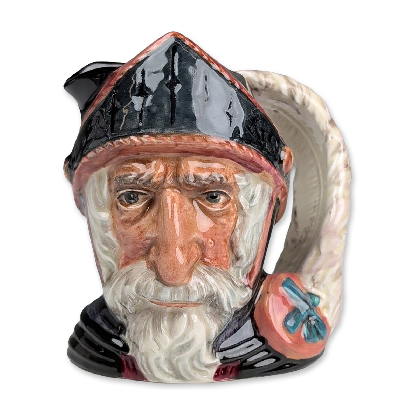 Royal Doulton Colorway Small Character Jug, Don Quixote D6460: Character jug in hand-painted glazed ceramic, depicting the literary figure Don Quixote. The figure is modeled with a gray beard and wears a black morion helmet with red trim. The handle is formed by 