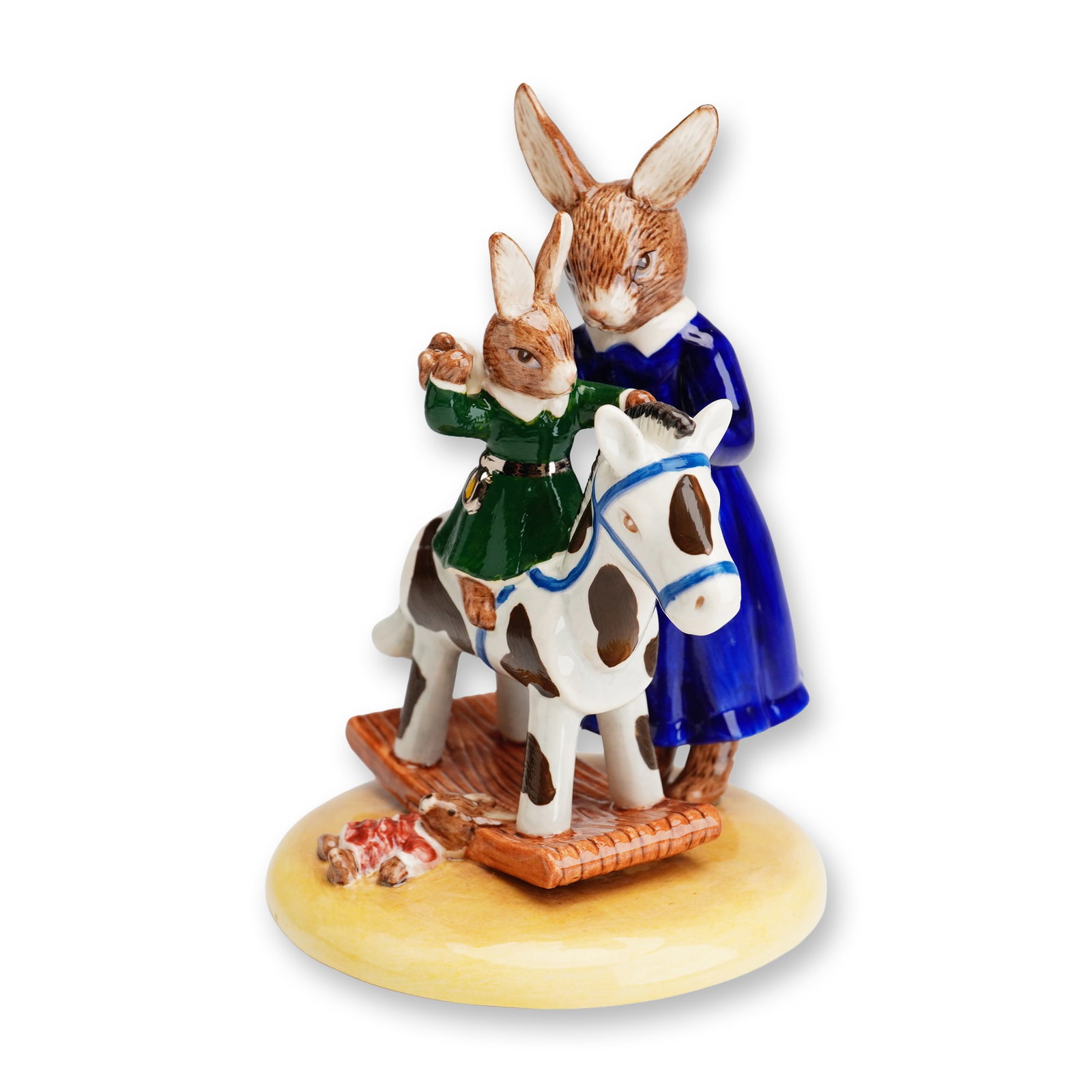 Royal Doulton Bunnykins Prototype Figurine, My Rocking Horse DB494: This Royal Doulton glazed porcelain figurine, titled My Rocking Horse (DB494), features an anthropomorphic scene of a mother rabbit in a vibrant blue dress with a white collar and silver-colored bow s