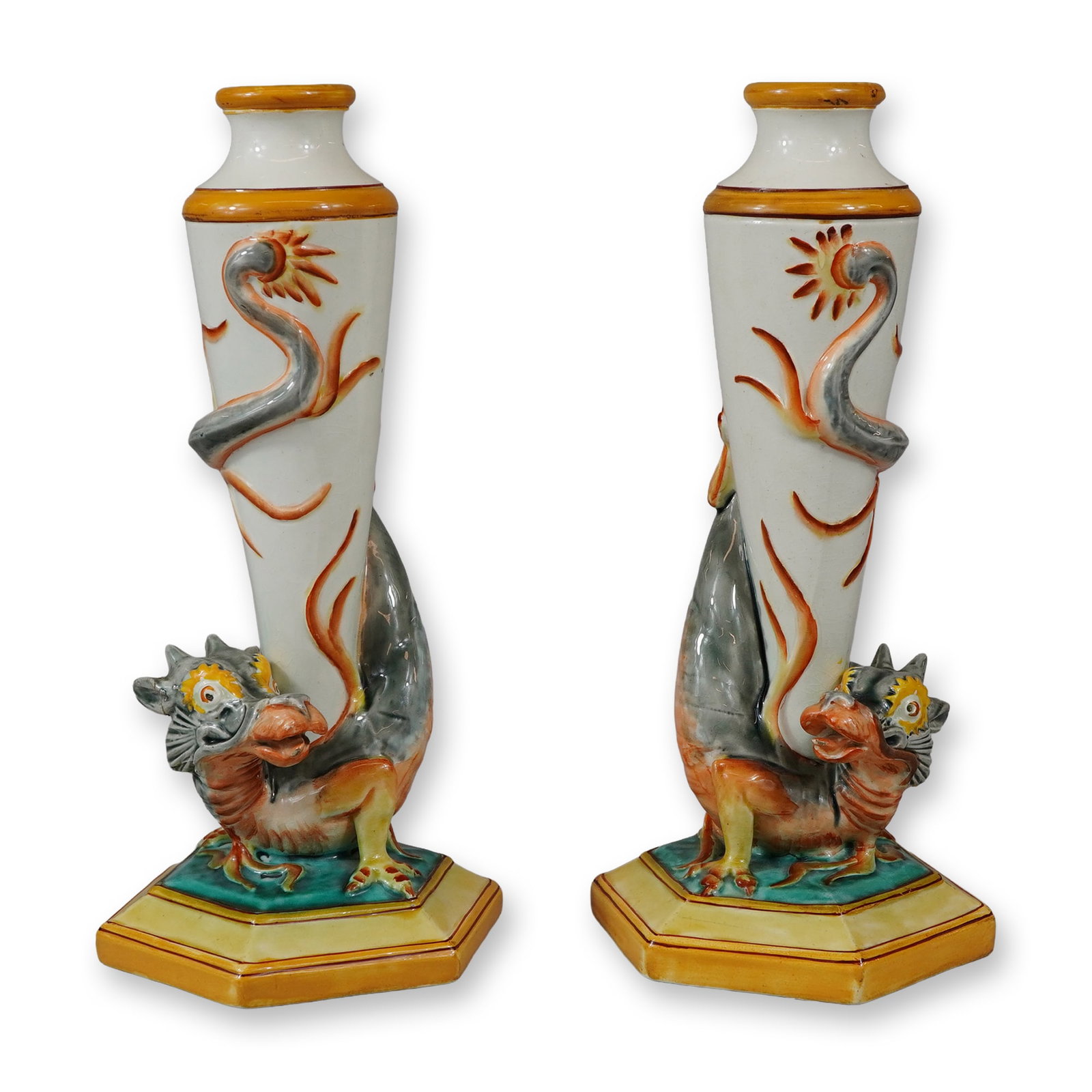 Pair of Wedgwood Majolica Mythical Beast Candlestick Holders: Each candlestick features a tapered, columnar shaft with a white lead-glazed finish. A highly modeled, three-dimensional mythical chimera or dragon is coiled around the central shaft, decorated in vib