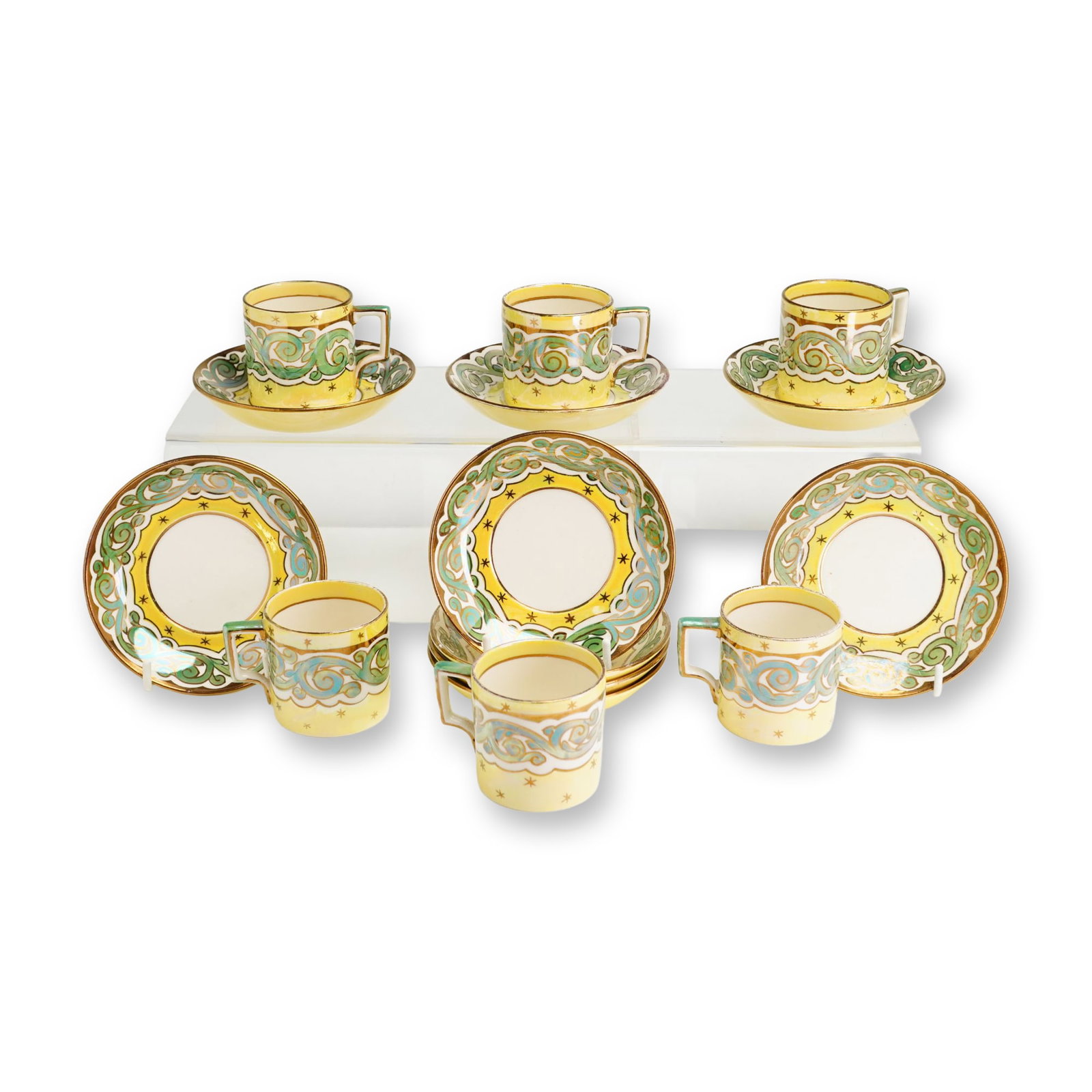 15-Piece Wedgwood Luster Glazed Demitasse Service: Wedgwood Etruria, group of luster glazed earthenware demitasse tea cups and saucers. The set features a vibrant yellow ground decorated with a central frieze of hand-painted scrolling foliate motifs i