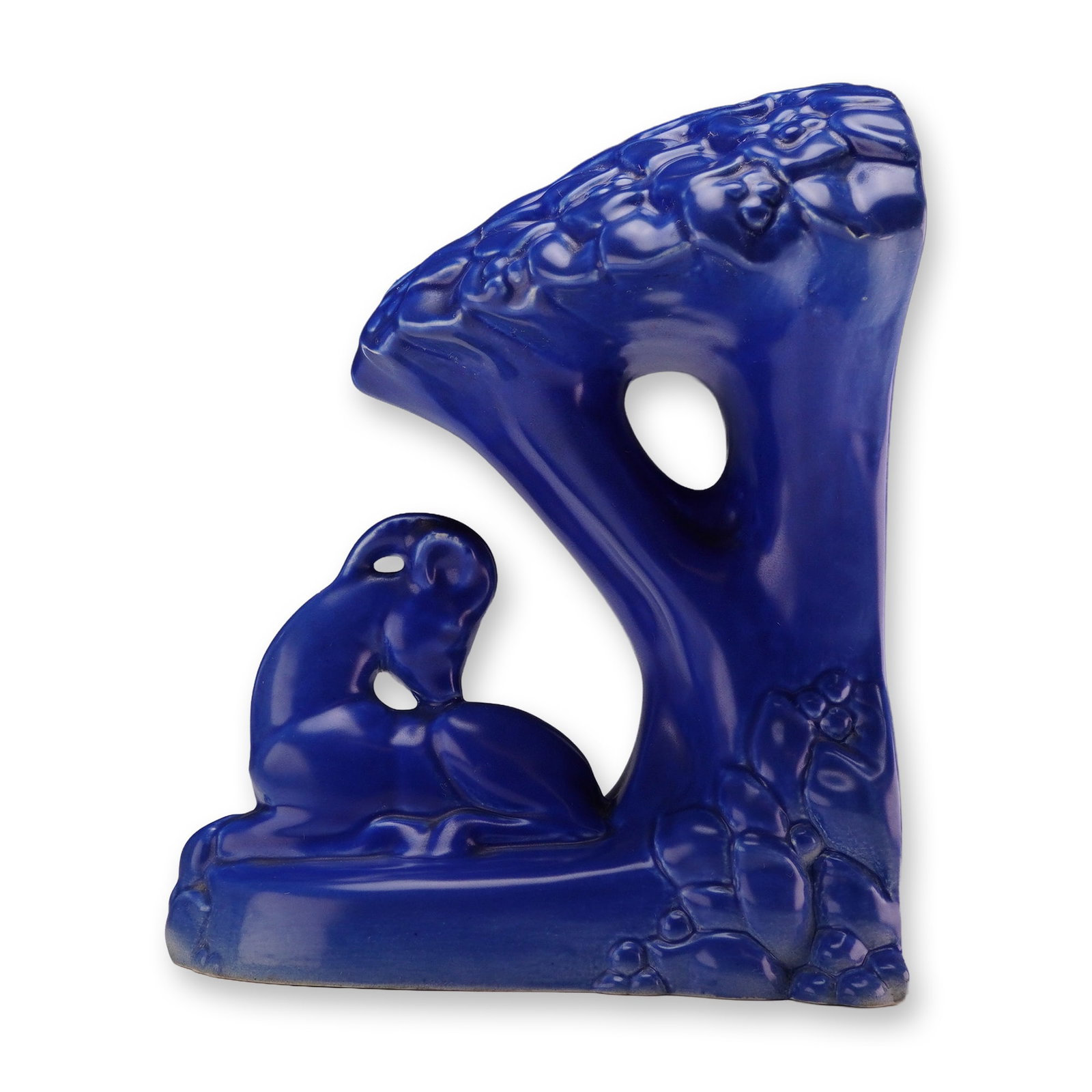 Wedgwood Art Deco Cobalt Blue Stag and Oak Tree Ceramic Bookend: This Art Deco ceramic bookend, produced by Wedgwood in England, features a stylized stag resting beneath a fan-shaped oak tree. The entire sculpture is covered in a vibrant, high-gloss cobalt blue gla