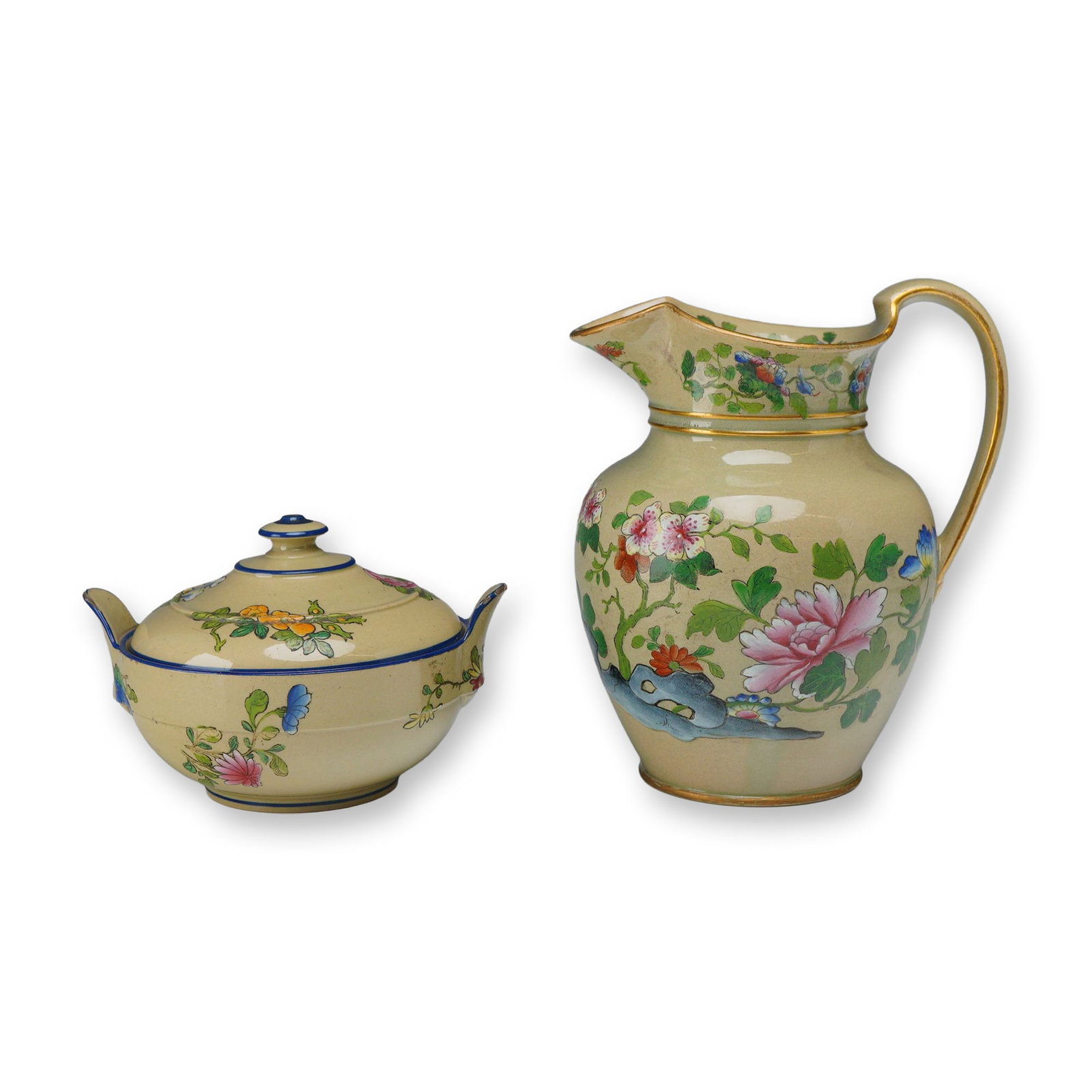2pc Wedgwood Asian Decorated Jug and Sugar Pot: This two-piece set consists of a ceramic jug and a matching double-handled lidded sugar pot, both produced by Wedgwood. The items are crafted from earthenware with a cream-colored glaze and decorated 