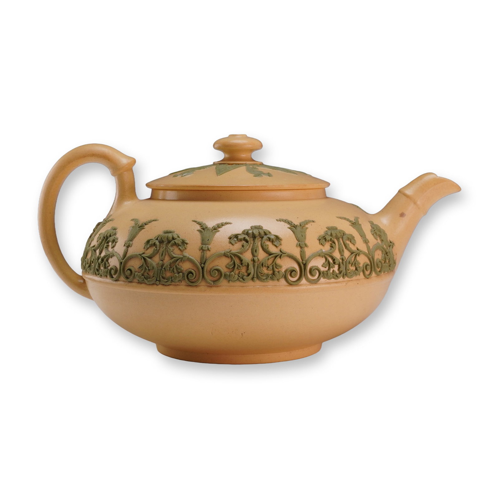Wedgwood Caneware Lidded Teapot with Green Arabesque Relief: A Wedgwood caneware lidded teapot dating to the first half of the 19th century. The vessel is crafted from buff-colored stoneware with a matte finish. The exterior features green sprigged relief decor