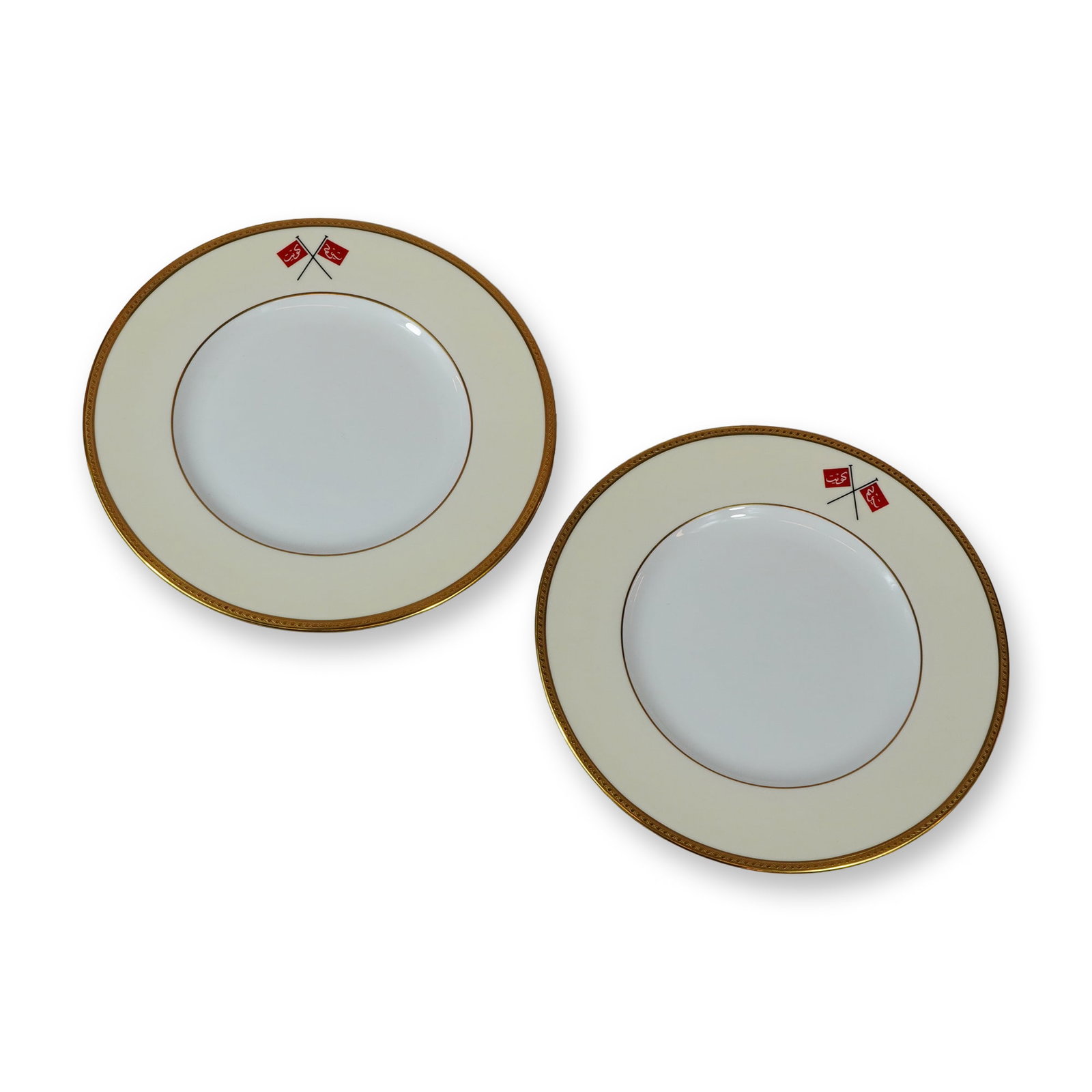 2pc Wedgwood Bone China Plates, Historical Flag of Kuwait W4243: A pair of circular English bone china plates manufactured by Wedgwood. Each plate features a wide ivory-colored rim accented by a thick, textured gold-gilded border at the edge and a secondary thin gi