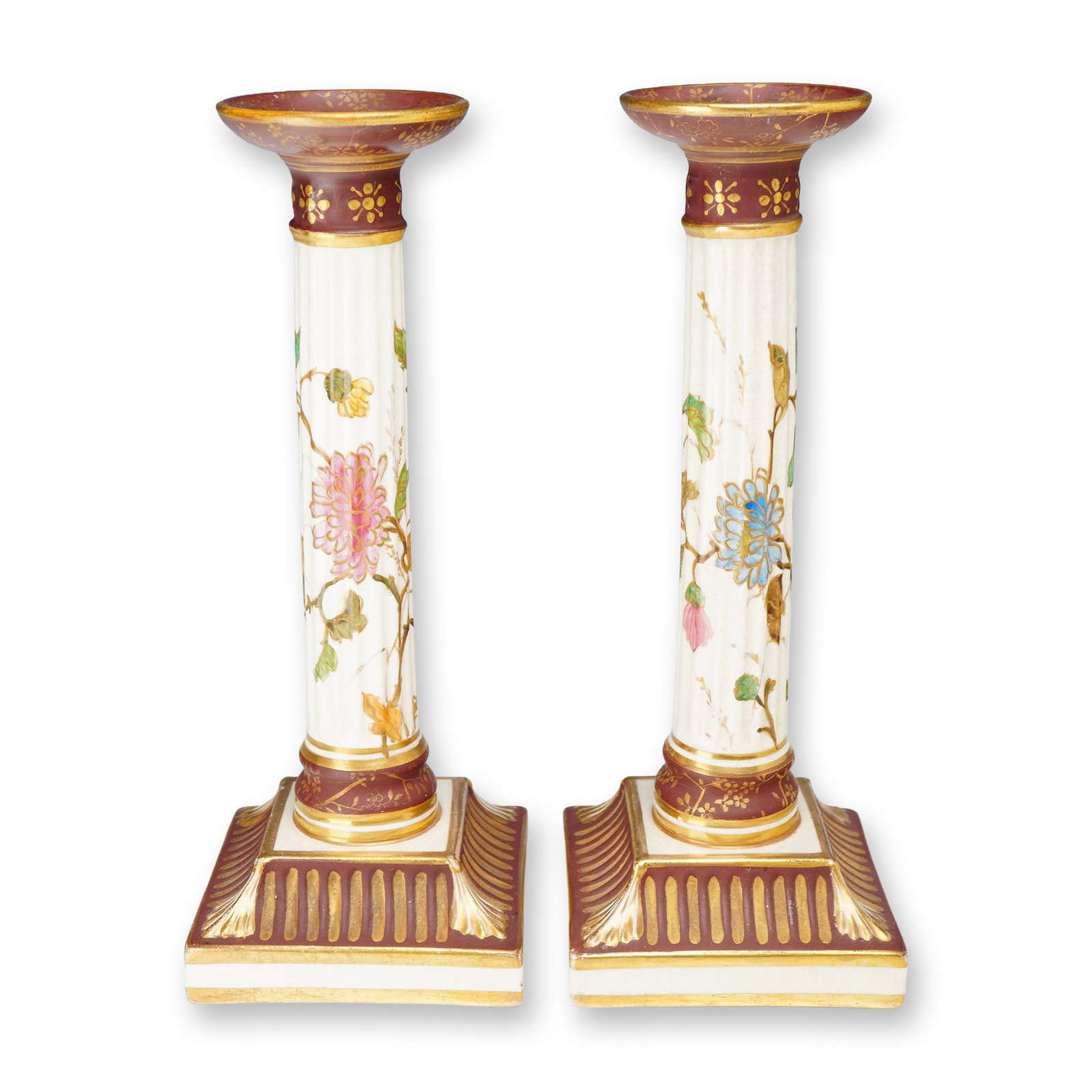 A Pair of Wedgwood Porcelain Columnar Candlesticks with Raised Gold Enhancements: A pair of Wedgwood porcelain candlesticks executed in a Neoclassical columnar form. Each candlestick features a white fluted central shaft decorated with hand-painted polychrome floral sprays, includi
