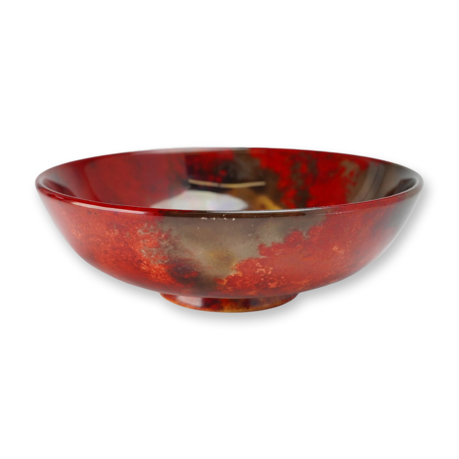 Royal Doulton Flambe Bowl: Featuring a copper-reduction glaze with mottled tones of crimson red, ochre, yellow, purple, and charcoal brown. The shallow circular form features a slightly flared rim and a raised foot ring. The hi