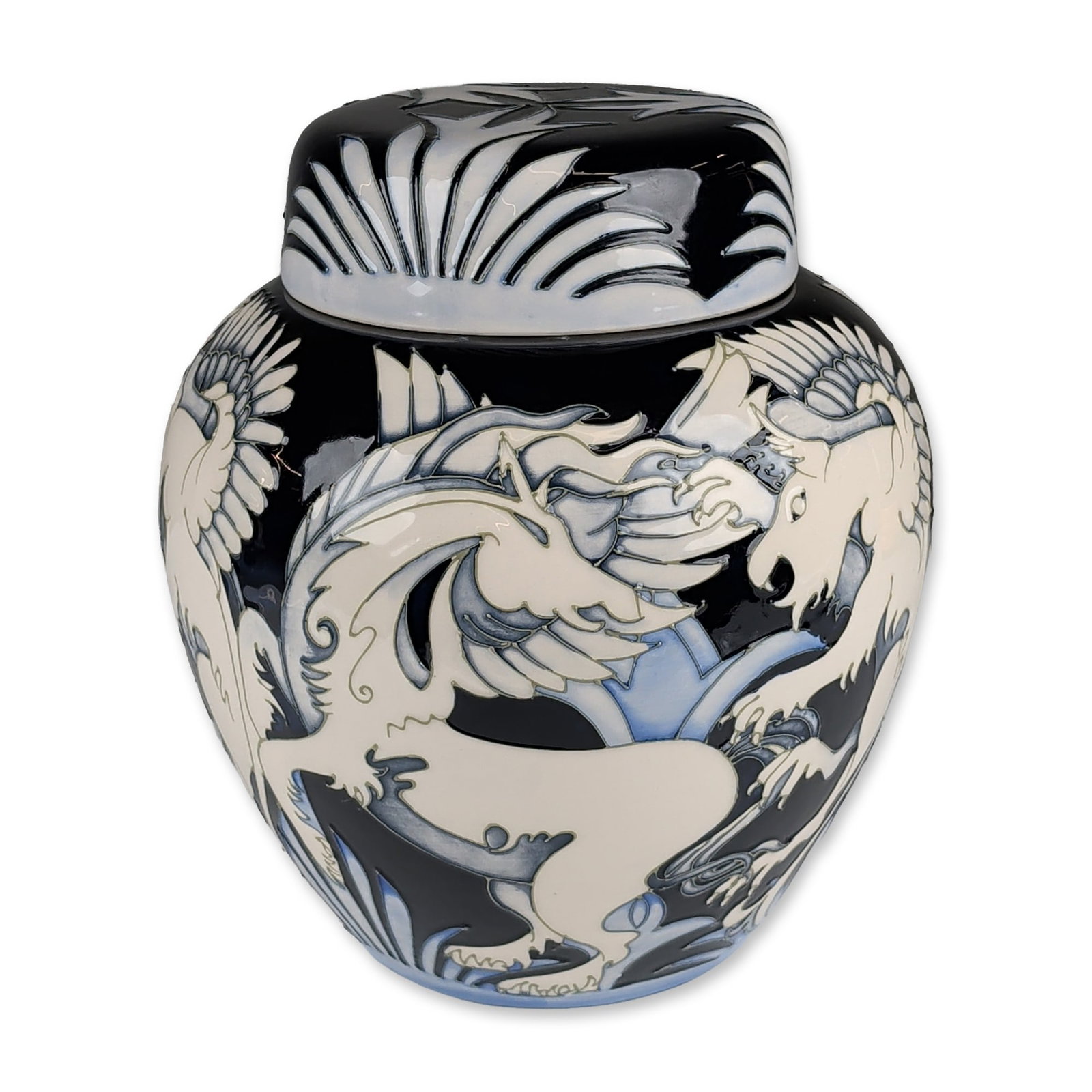 Moorcroft Pottery by Vicky Lovatt Lidded Ginger Jar, Dance of the Griffins: Limited edition. This tube-lined earthenware vessel features stylized mythical winged creatures in creamy white and pale blue glazes set against a deep navy blue ground. The coordinating lid displays 