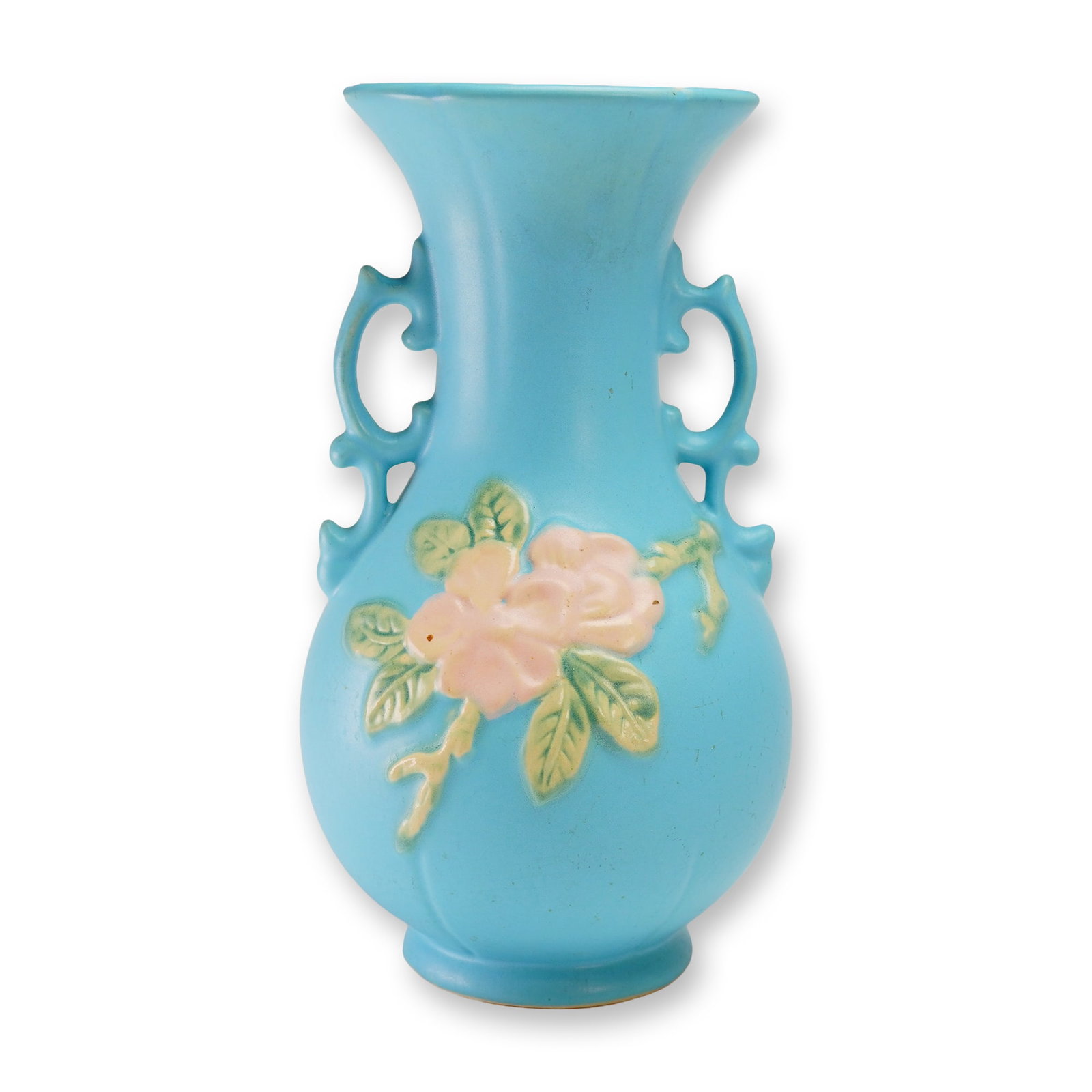 Weller Pottery Blue Vase with Pink Embossed Flower, Wild Rose: The vessel features a matte turquoise-blue glaze on an ovoid body. The front face is decorated with a raised floral relief consisting of pink blossoms and green foliage. The form is flanked by two sty