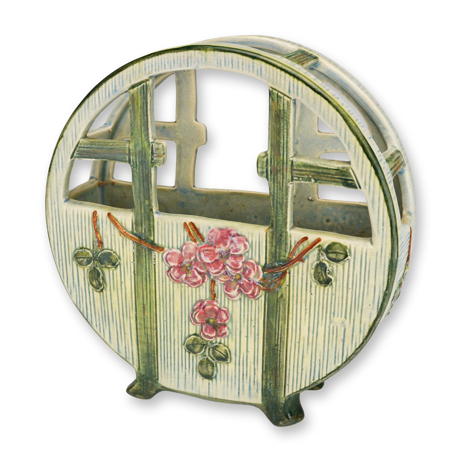 Weller Pottery Klyro Basket Vase: Basket vase of circular, open-work form with an integral four-footed base. The ceramic vessel is decorated with relief-molded wild rose blossoms in shades of pink and red on thorny brown branches with