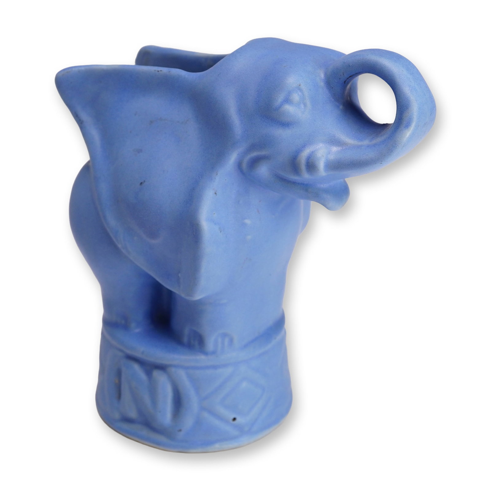 Niloak Pottery Circus Elephant Planter: This vintage figural ceramic planter or bud vase is a product of the Niloak Pottery Company of Benton, Arkansas. The piece depicts a stylized circus elephant with a raised, looped trunk and simplified