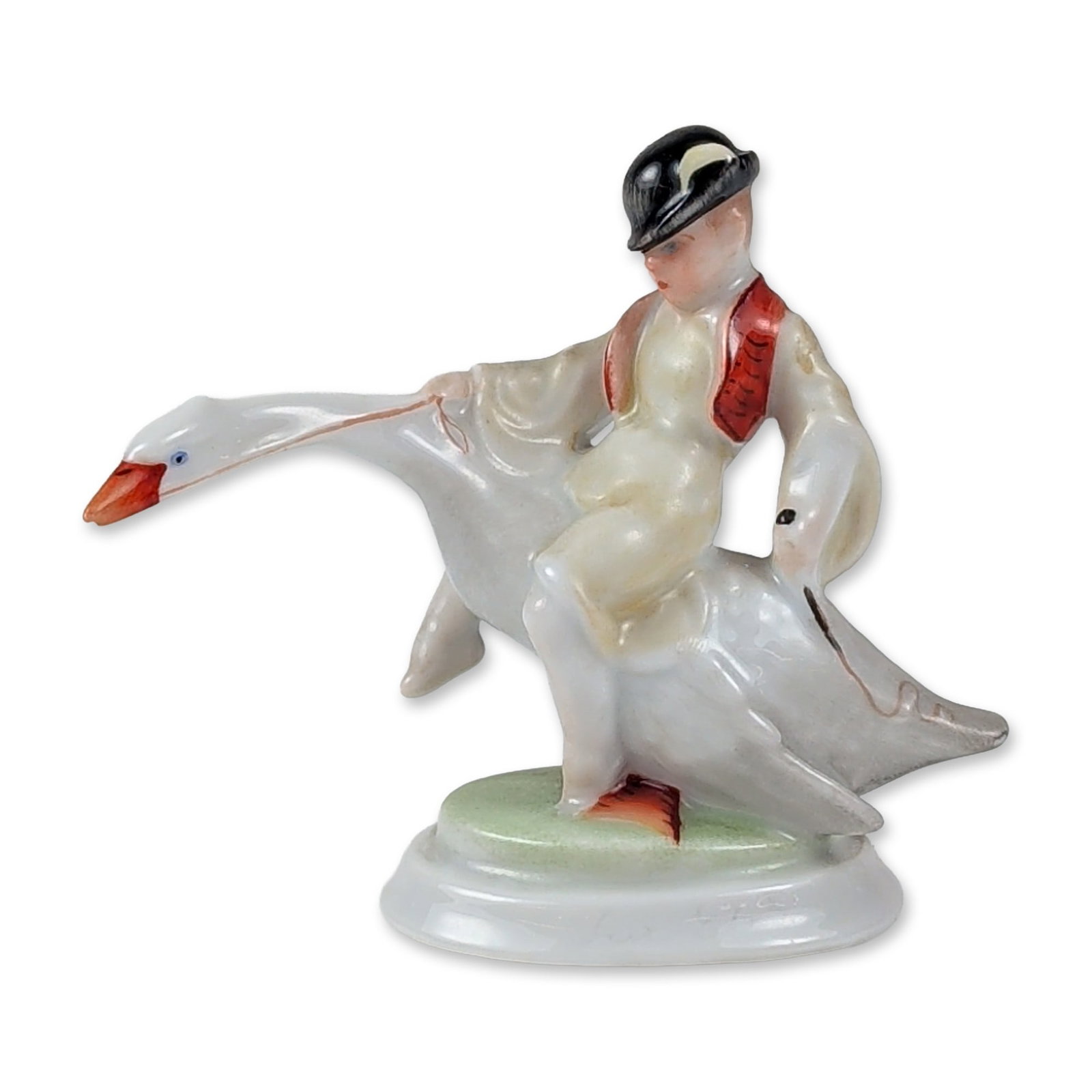 Herend Hungary Porcelain Boy Riding Goose Figurine, Ludas Matyi: Herend porcelain figurine depicting a young boy named Ludas Matyi in traditional Hungarian folk dress, including a black hat and red waistcoat, riding a white goose. The figurine is crafted from glaze