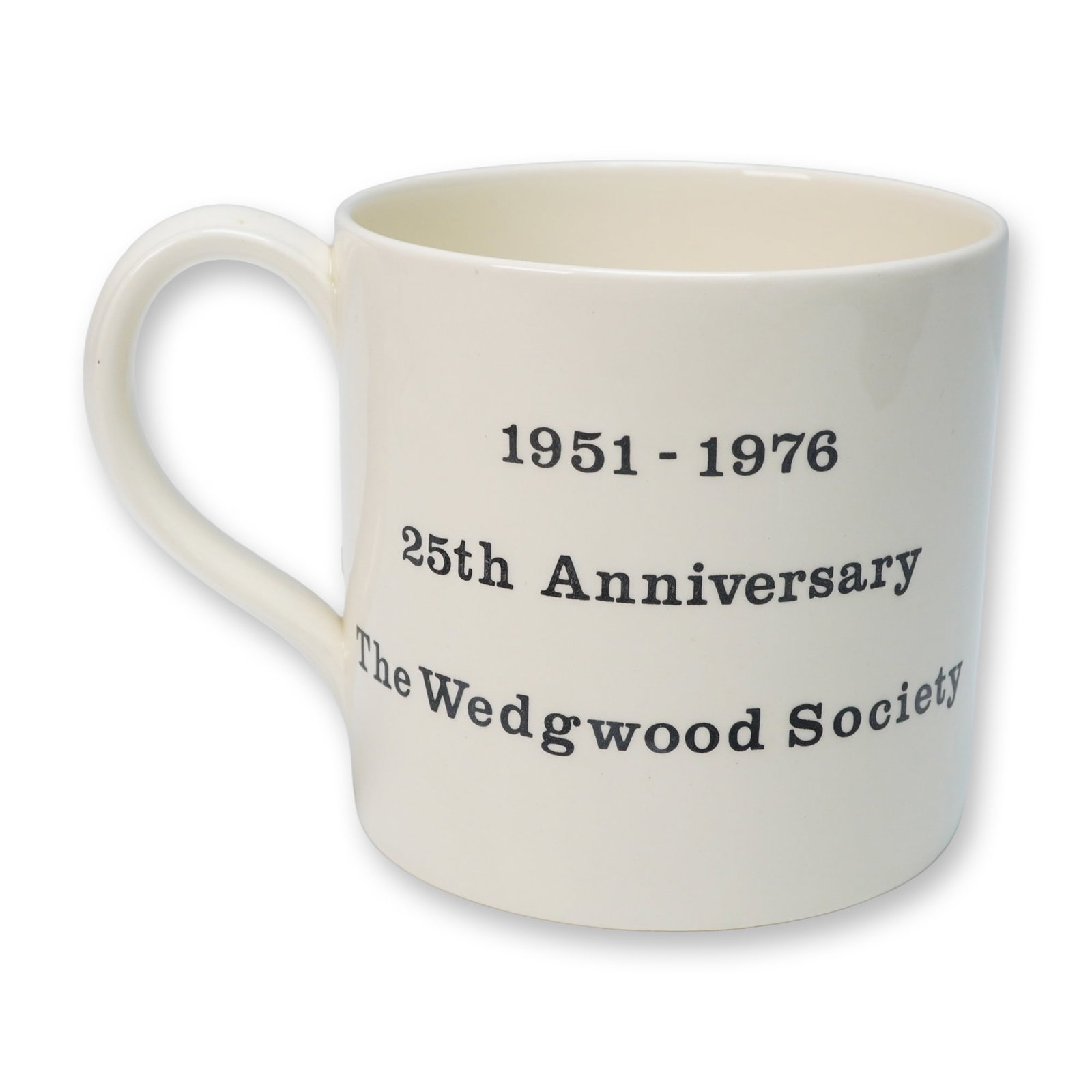 A Wedgwood Society 25th Anniversary Commemorative Mug: A cream-colored, glazed ceramic mug with a single handle by Wedgwood. The front is decorated with black printed text reading "1951 - 1976", "25th Anniversary", and "The Wedgwood Society". The reverse