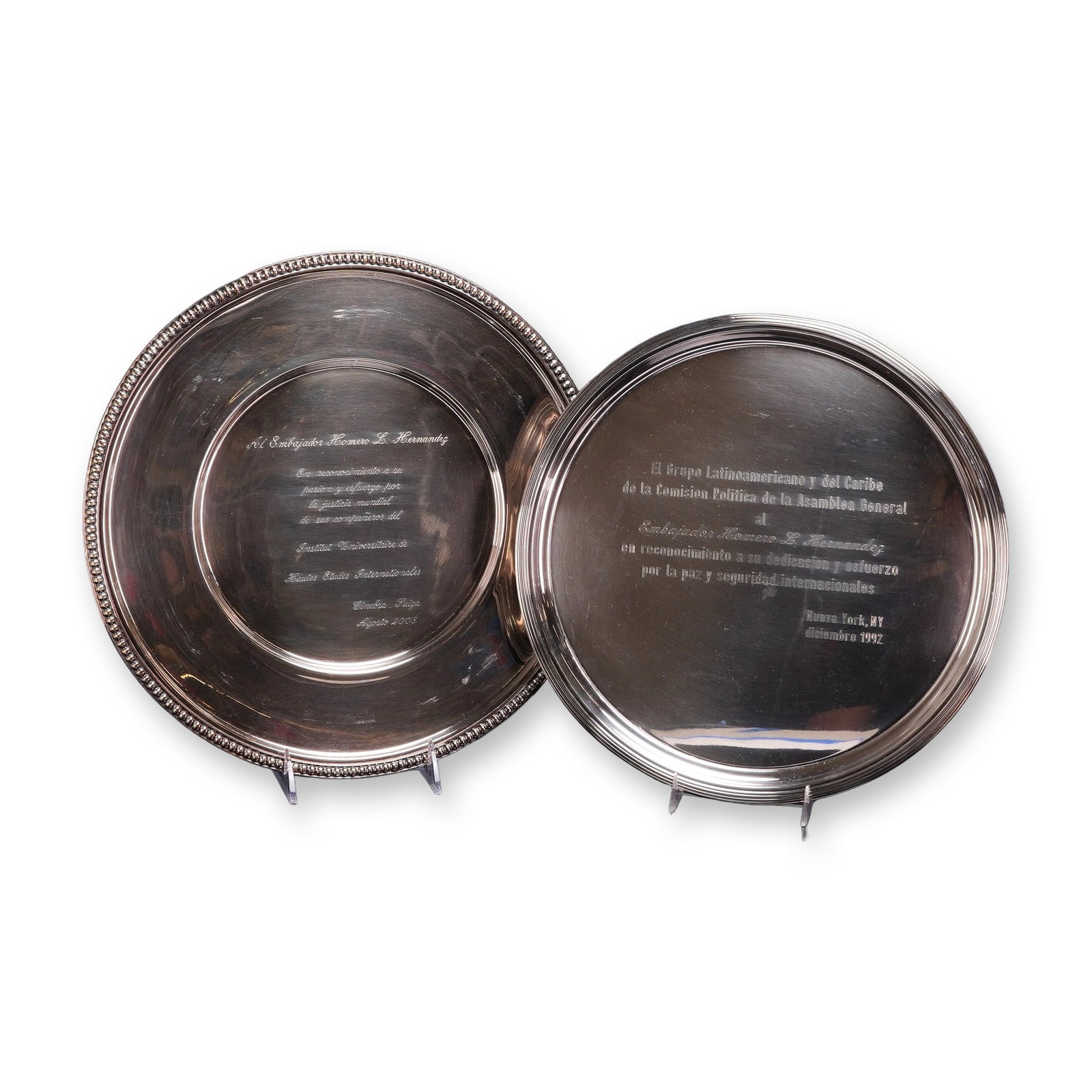 Two Lunt Silversmiths and Touzeau Silver-Plated Presentation Platters: A pair of silver-plated presentation platters or salvers awarded to Ambassador Homero L. Hernandez. The first platter features a stepped rim design and is produced by Lunt Silversmiths as part of a