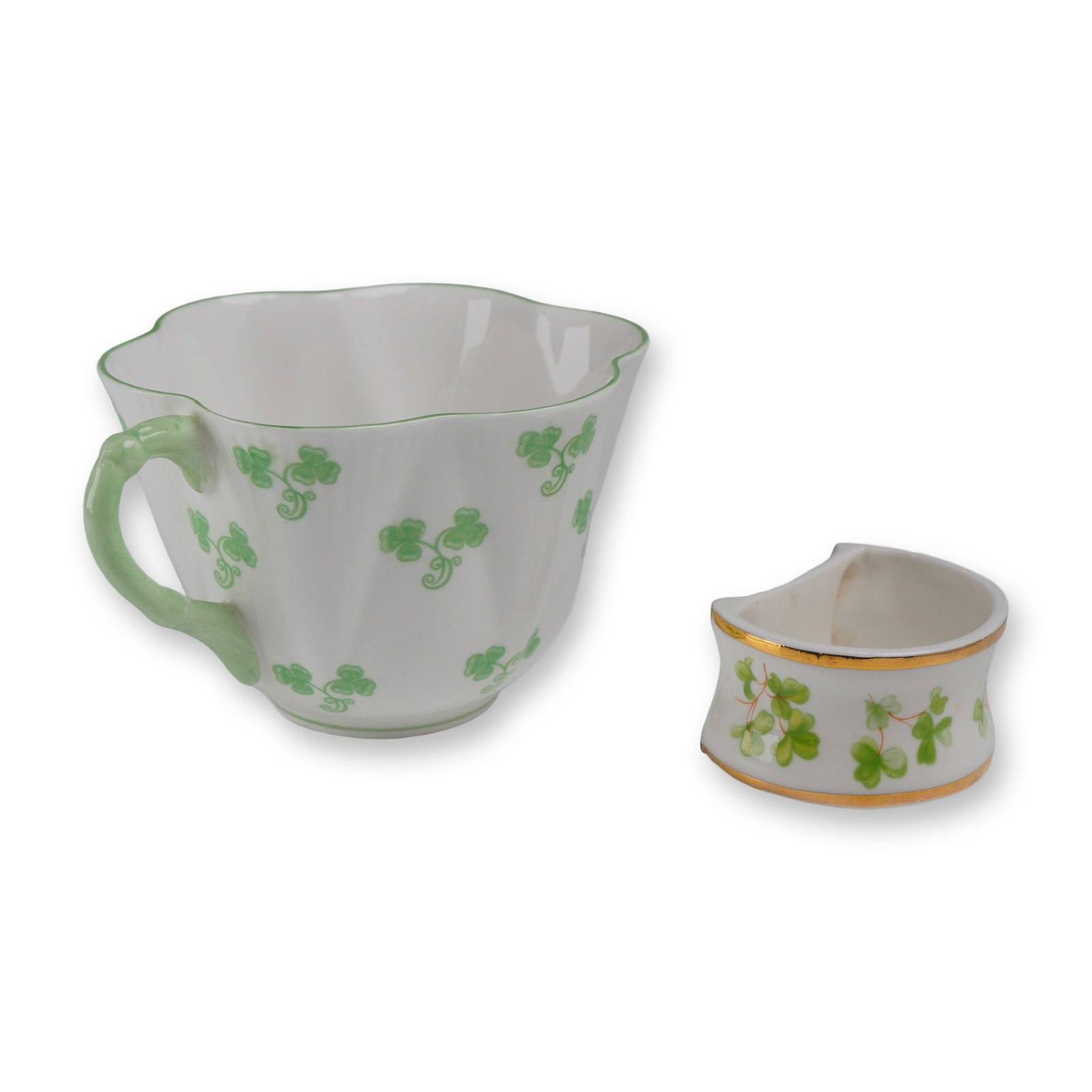 2pc Shelley and Lane End Shamrock Cup and Napkin Ring: This lot consists of two pieces of English fine bone china featuring traditional shamrock motifs. The first item is a Shelley teacup in the iconic "Dainty" shape, distinguished by its fluted porcelain