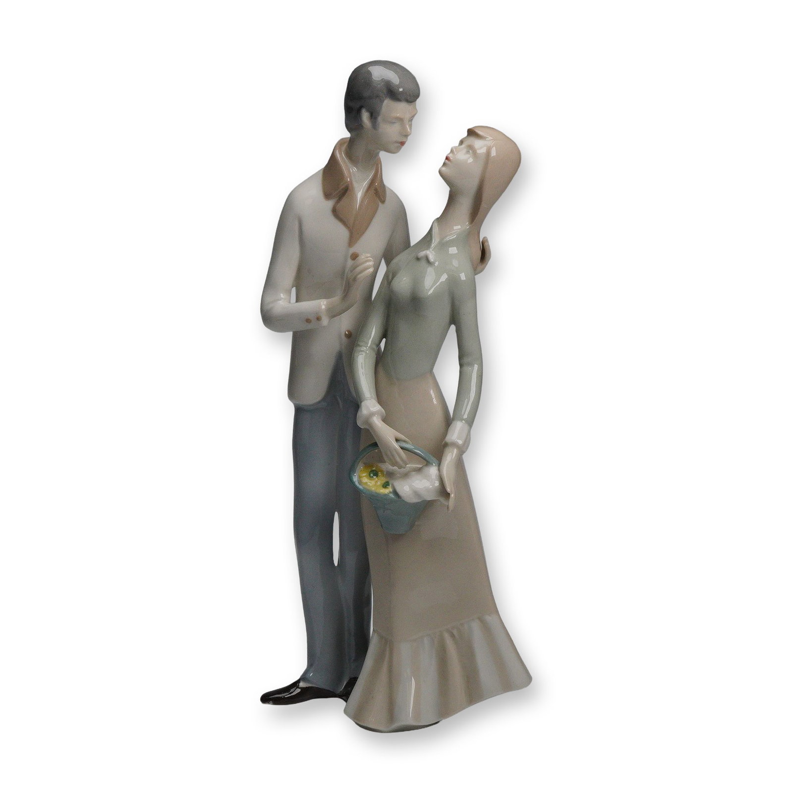 GDR Lippelsdorf Young Couple Porcelain Figurine: A glazed porcelain figurine from Lippelsdorf in the German Democratic Republic depicting a young couple standing closely together, the woman holding a small basket of yellow flowers and dressed in a
