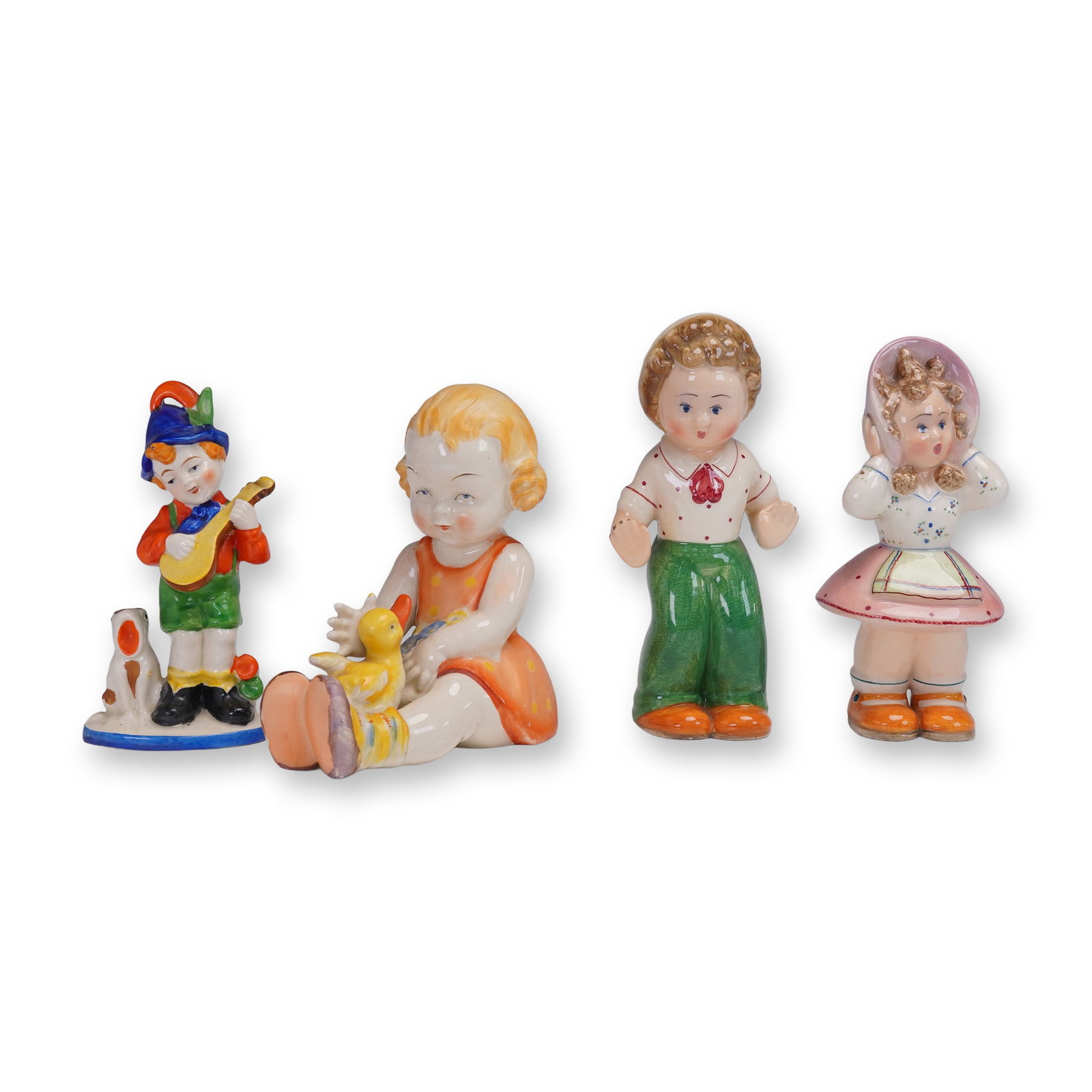 4pc Vintage Porcelain Childhood Themed Figurines: A group of four colorful figures including a boy in green shorts playing a guitar beside a dog, a seated girl in an orange dress with a yellow duck, and a pair of standing children with the boy in gre