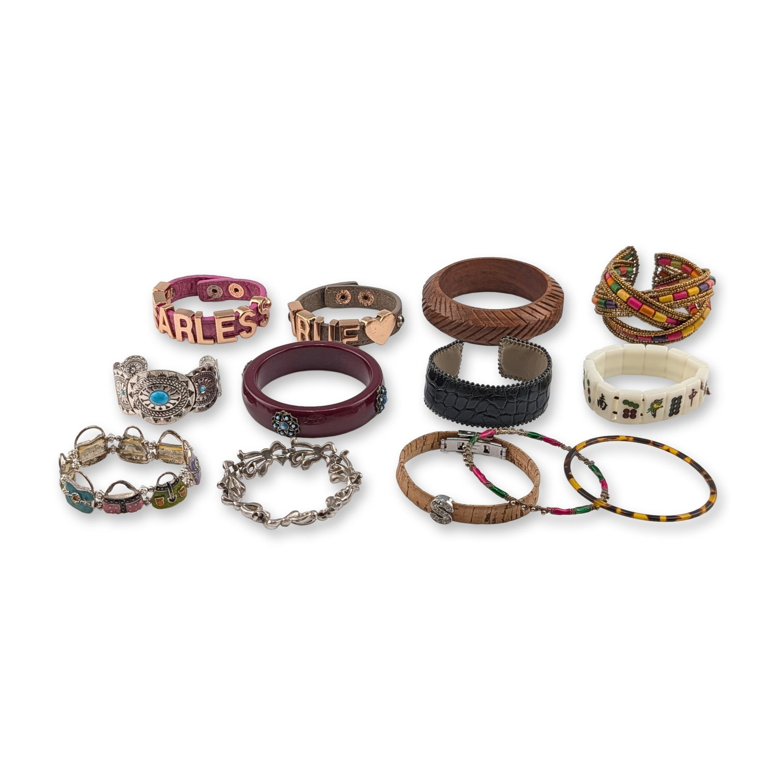 13pc Assortment of Fashion and Costume Bracelets: An assortment of thirteen fashion and costume jewelry bracelets in a variety of contemporary and bohemian styles. The collection includes a natural cork strap bracelet with a silver-tone S charm, feat