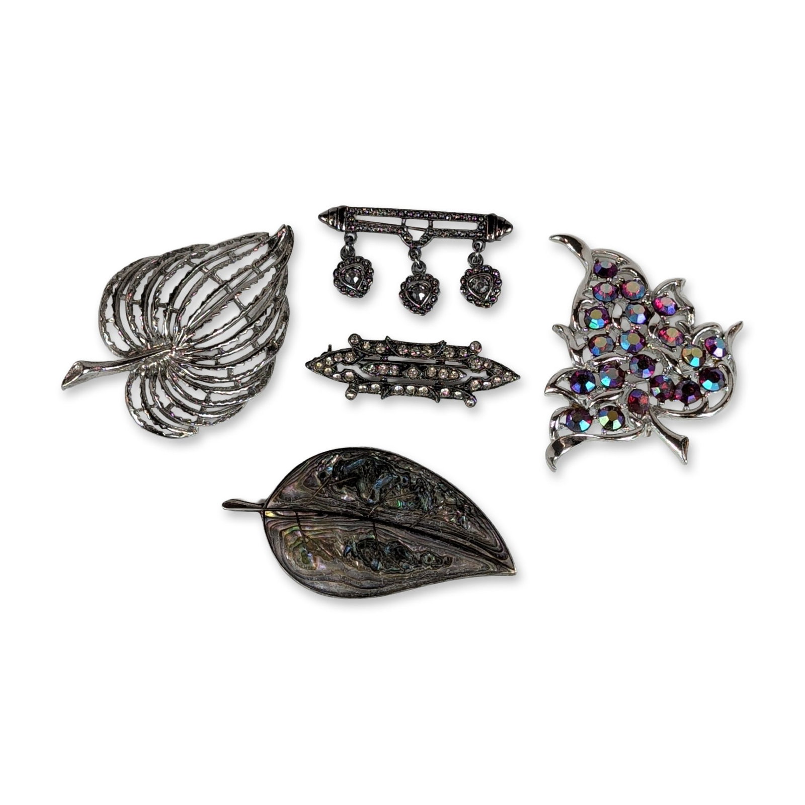 5pc Vintage Silver Tone and Sterling Brooches: Assortment of vintage brooches in silver tone and sterling silver, featuring botanical and geometric motifs. Includes a Sarah Coventry silver tone leaf brooch set with faceted purple and blue aurora b