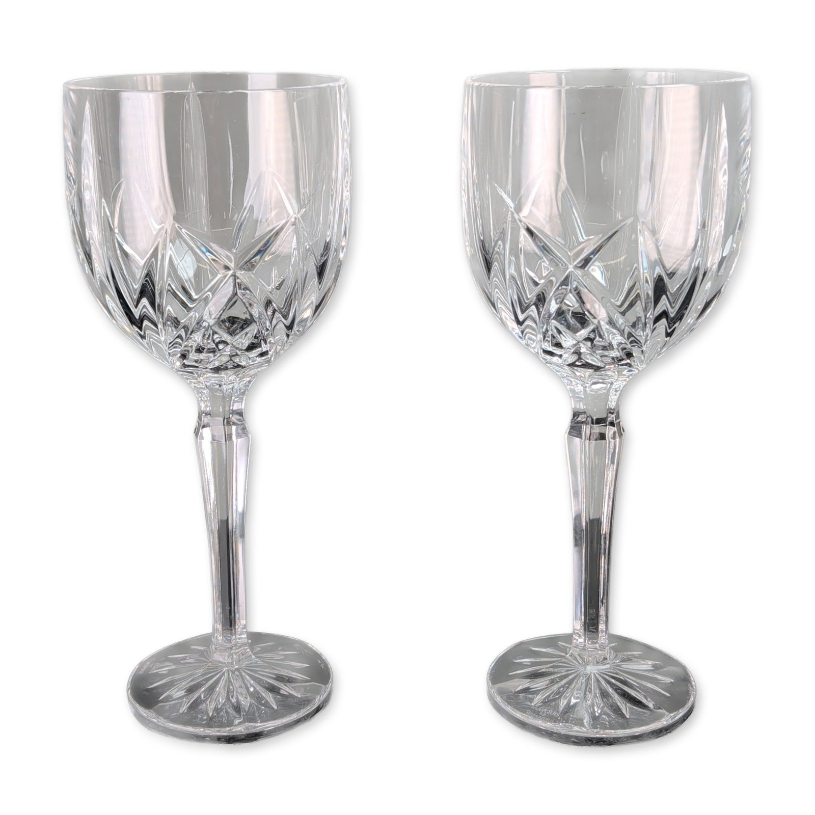Pair of Marquis by Waterford Brookside Crystal Goblets: Marquis by Waterford. Pair of wine goblets in lead crystal, in the Brookside pattern. Each piece features a bowl decorated with vertical wedge cuts over a lower band of crisscross diamond cuts, a face