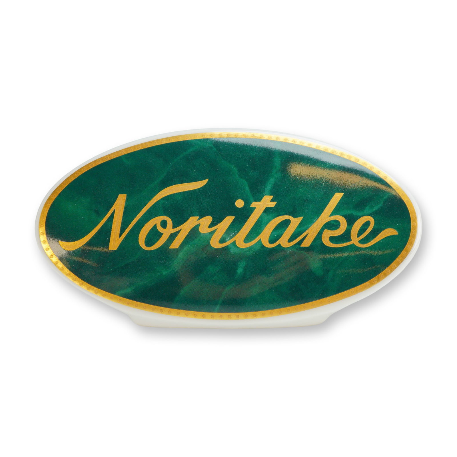 Noritake Porcelain Retail Display Name Plaque: The piece features an oval-shaped plaque with a central green faux-marble field. The brand name Noritake is applied in stylized gold script across the center. A delicate gold-toned patterned border fr