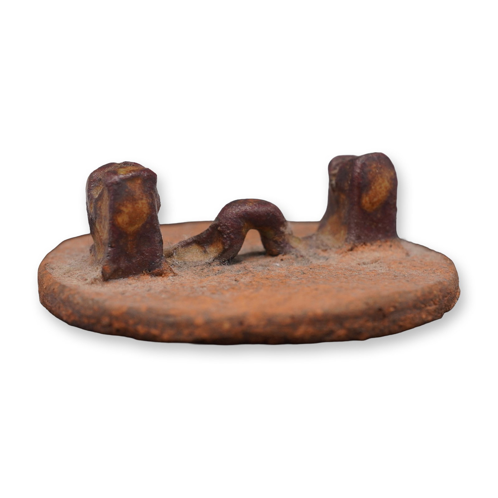 Ancient Style Ceramic Fragment with Raised Form: This ancient-style ceramic object features a weathered, textured surface and a raised, abstract form on a circular base. The reddish-brown clay body and hand-applied detailing give it the appearance o