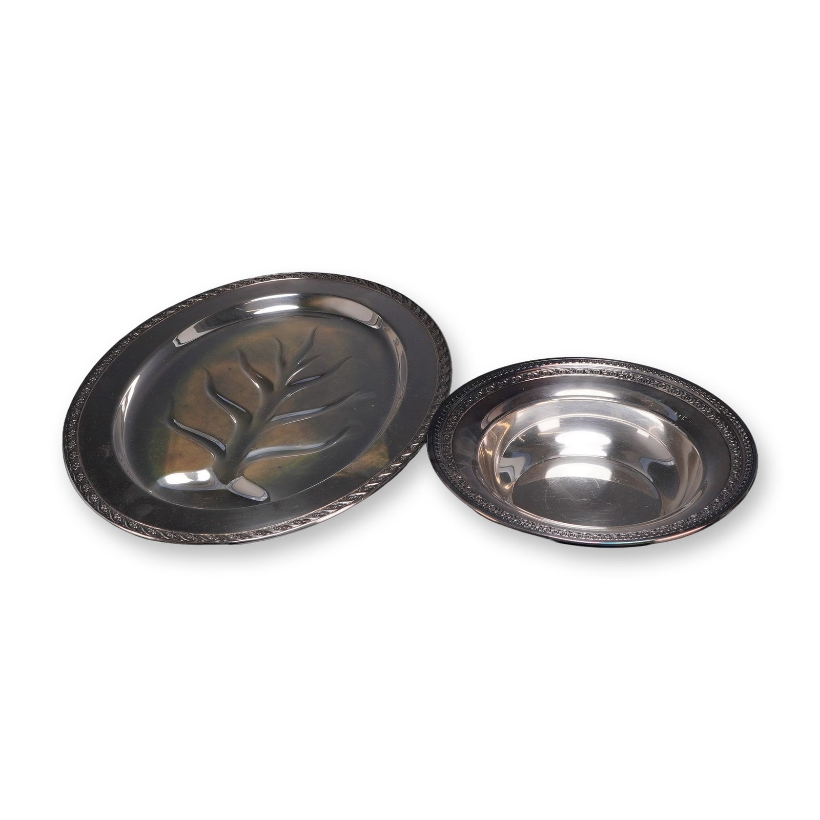 2pc Wm. Rogers & Son and Reed & Barton Silver-Plated Serving Pieces: This two-piece serving set consists of an oval meat platter by Wm. Rogers & Son in the Spring Flower pattern and a round serving bowl by Reed & Barton. The oval platter features a tree-and-well design