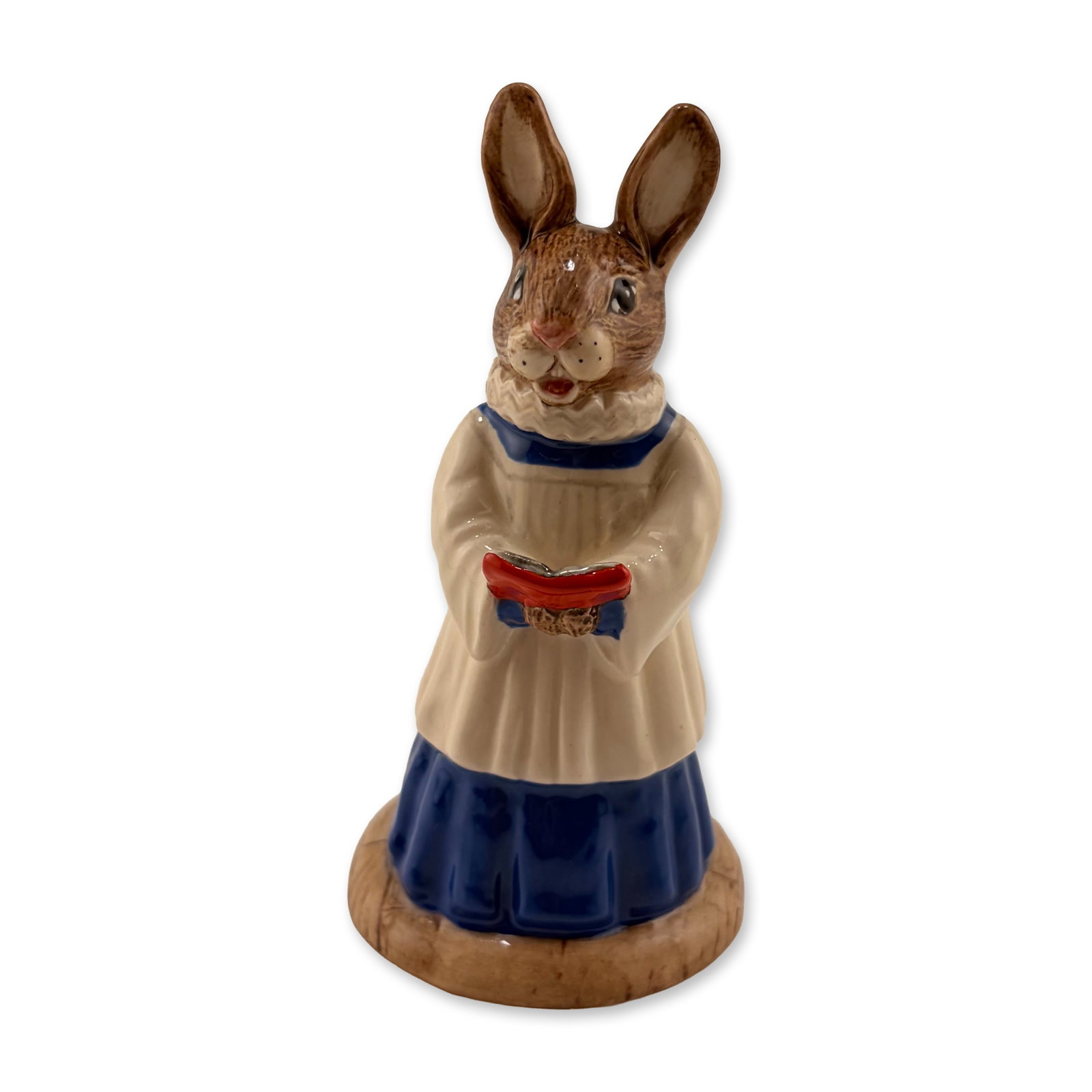 Royal Doulton Prototype Bunnykins Figurine, Choir Singer: An anthropomorphic rabbit figurine with a lustrous glazed finish, depicted as a choir boy singing from a red hymn book. He wears a white square-neck surplice over a blue cassock, with the finely model
