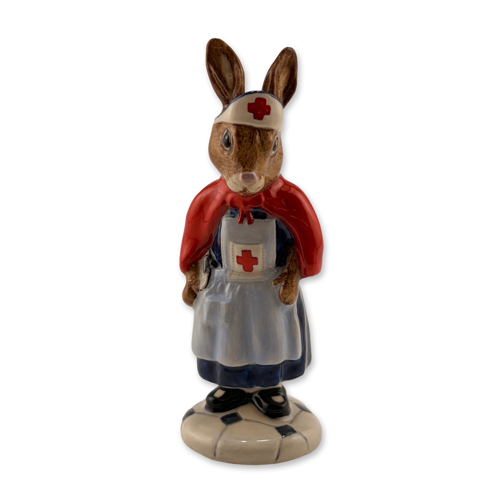 Royal Doulton Prototype Bunnykins Figurine, Nurse: A rare Royal Doulton Bunnykins prototype figurine depicting a rabbit nurse, beautifully presented in a dark blue uniform with a light blue apron, white nursing cap featuring a dark blue band, and a st