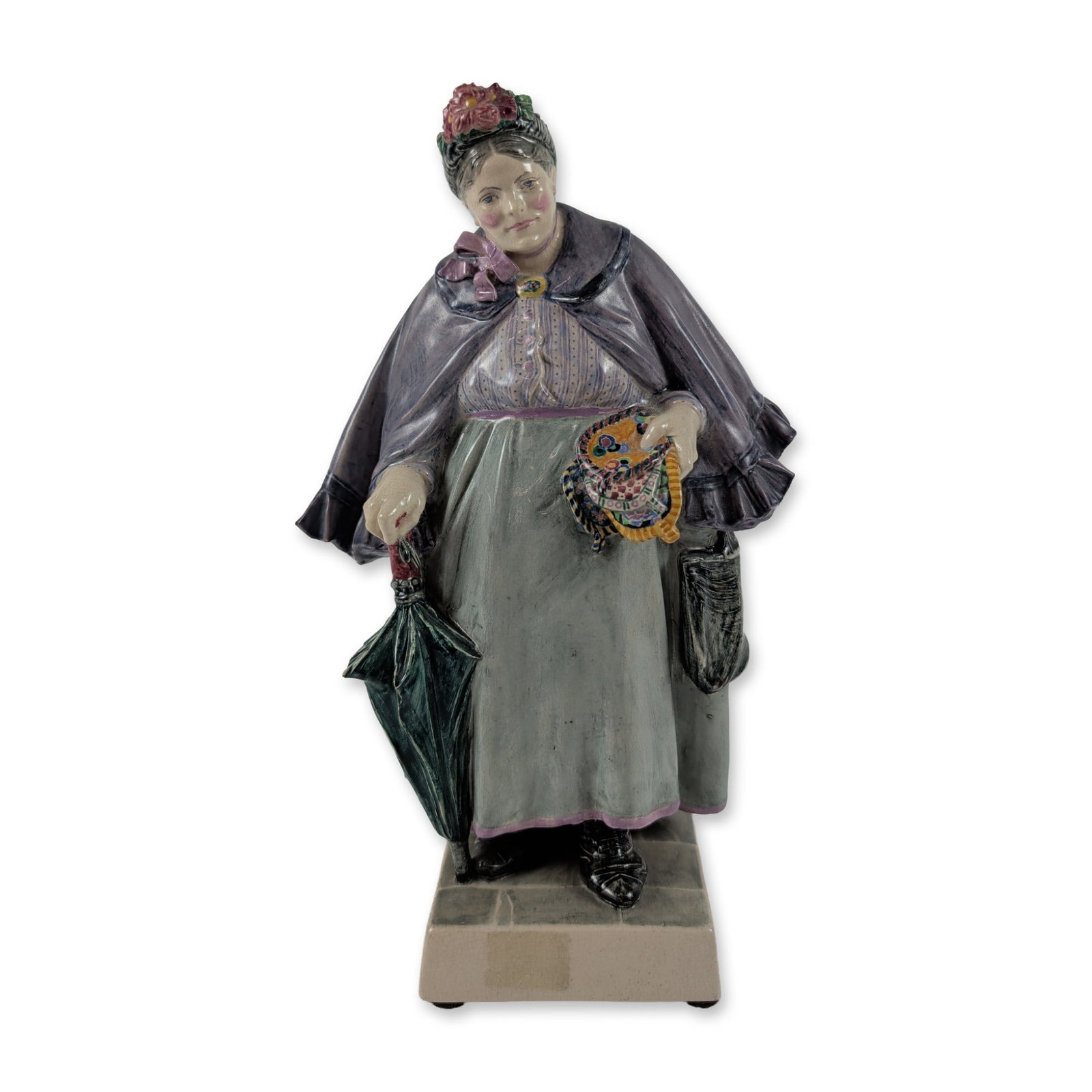 Charles Vyse Chelsea Pottery The Kettle Holder Figurine: Charles Vyse (British, 1882-1971), 1925. Studio pottery figure titled The Kettle Holder in glazed ceramic, depicting a female vendor in a gray skirt with purple trim and a ruffled purple mantle. She c