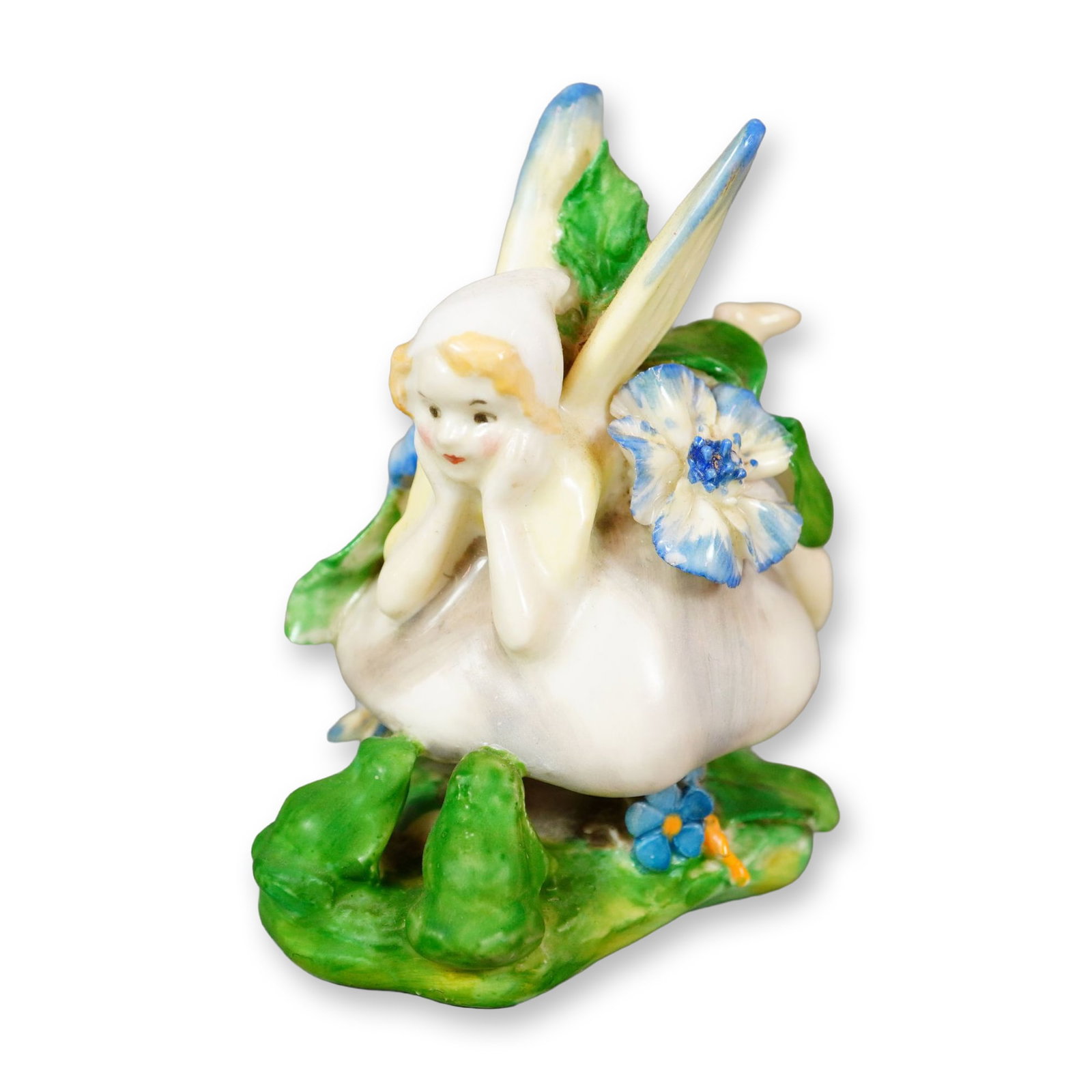 Doulton Porcelain Figurine, Fairy HN1395: Hand-painted figure depicting a child-like fairy seated on a mushroom and surrounded by blue flowers. Part of the Fairies Series, Style 3, and the Harradine Classics collection. Decorated in blue and 