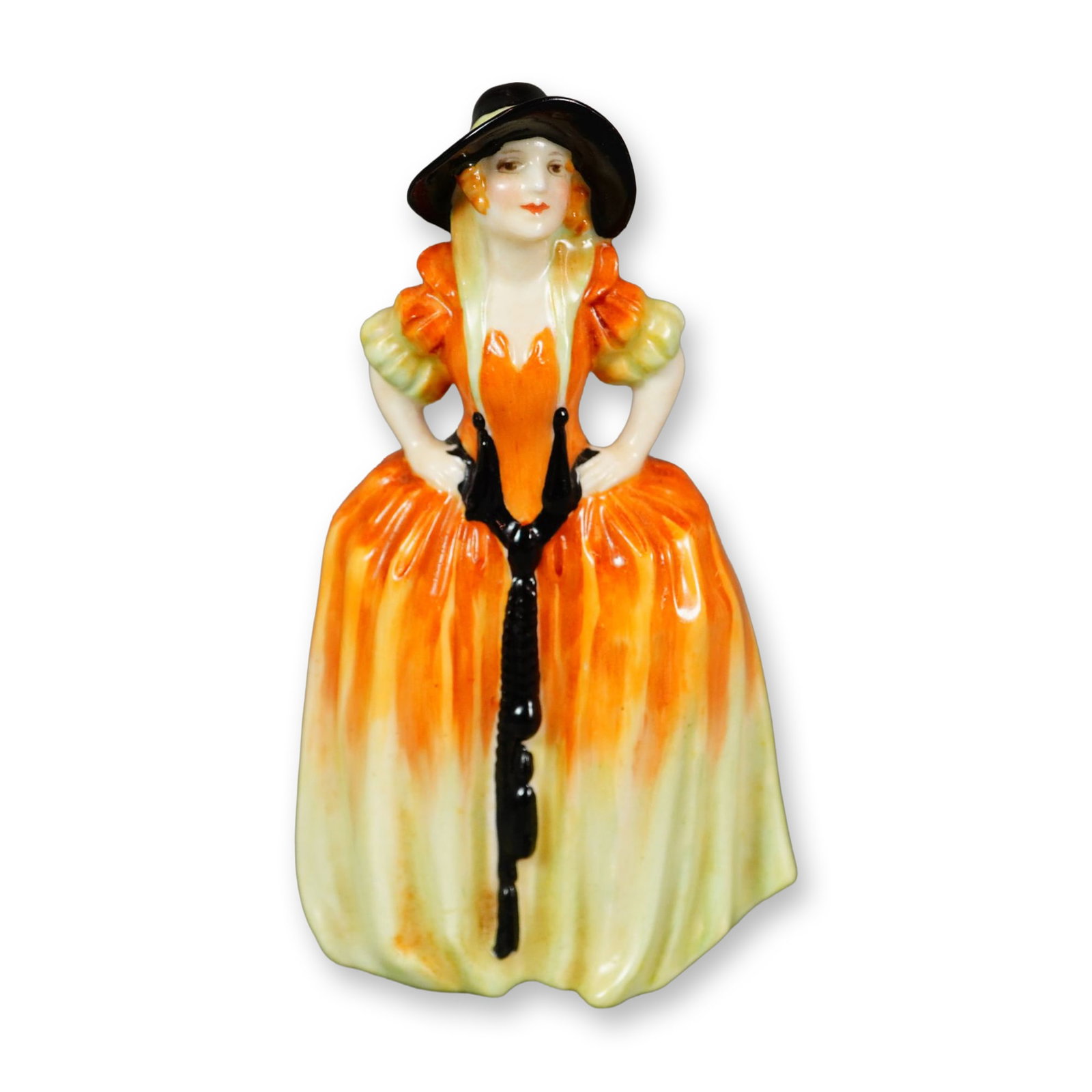 Royal Doulton Figurine, Patricia M8: Hand painted figure of a woman in an orange and yellow dress, and a wide brim black hat. Royal Doulton backstamp. Dimensions: 2.5"L x 1.75"W x 4"H Manufacturer or Brand: Royal Doulton Country of Origi