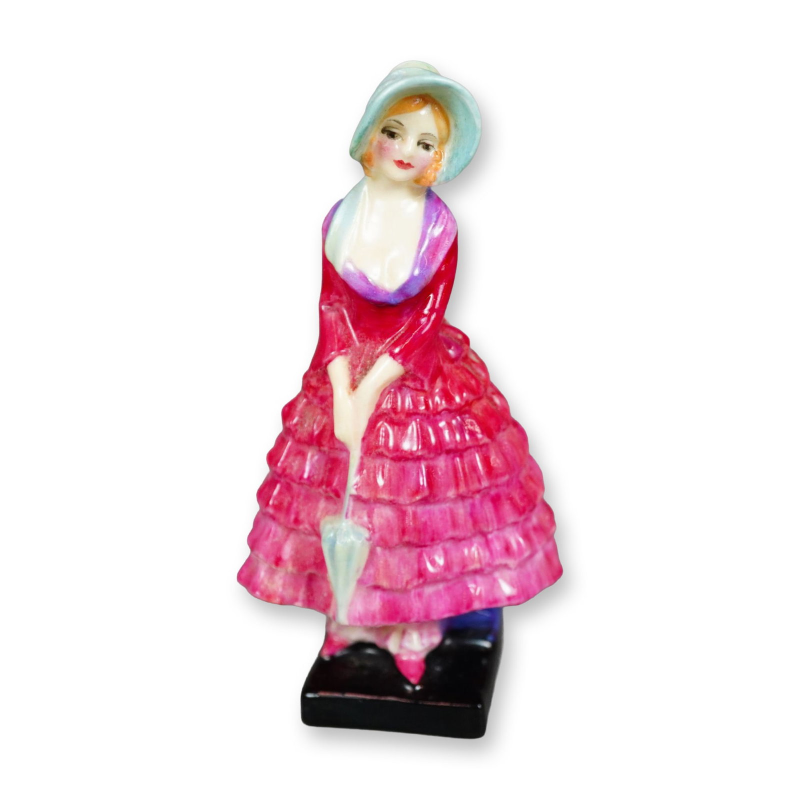 Royal Doulton Figurine, Priscilla M24: Hand painted figure of a young woman in a pink ruffled dress holding a blue parasol. Royal Doulton backstamp. Dimensions: 2"L x 1.5"W x 3.75"H Manufacturer or Brand: Royal Doulton Country of Origin: E