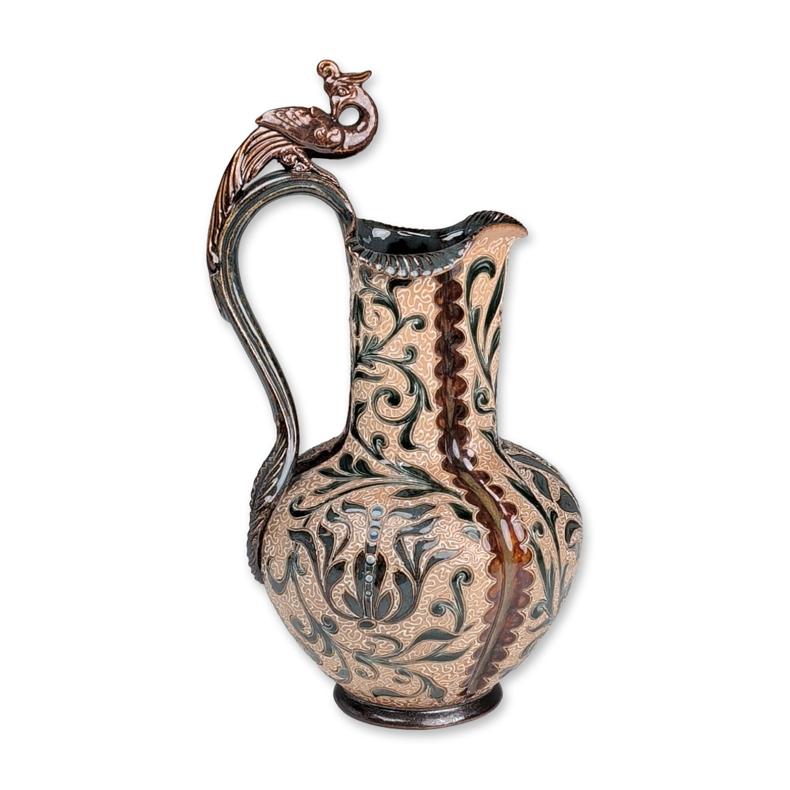 Doulton Lambeth by Mark V. Marshall Stoneware Peacock Handle Ewer: The vessel features a bulbous body and a tall neck with a flared, shaped rim. An ornate scrolling handle terminates in a stylized peacock perched on the handle. Decoration consists of hand-incised sgr