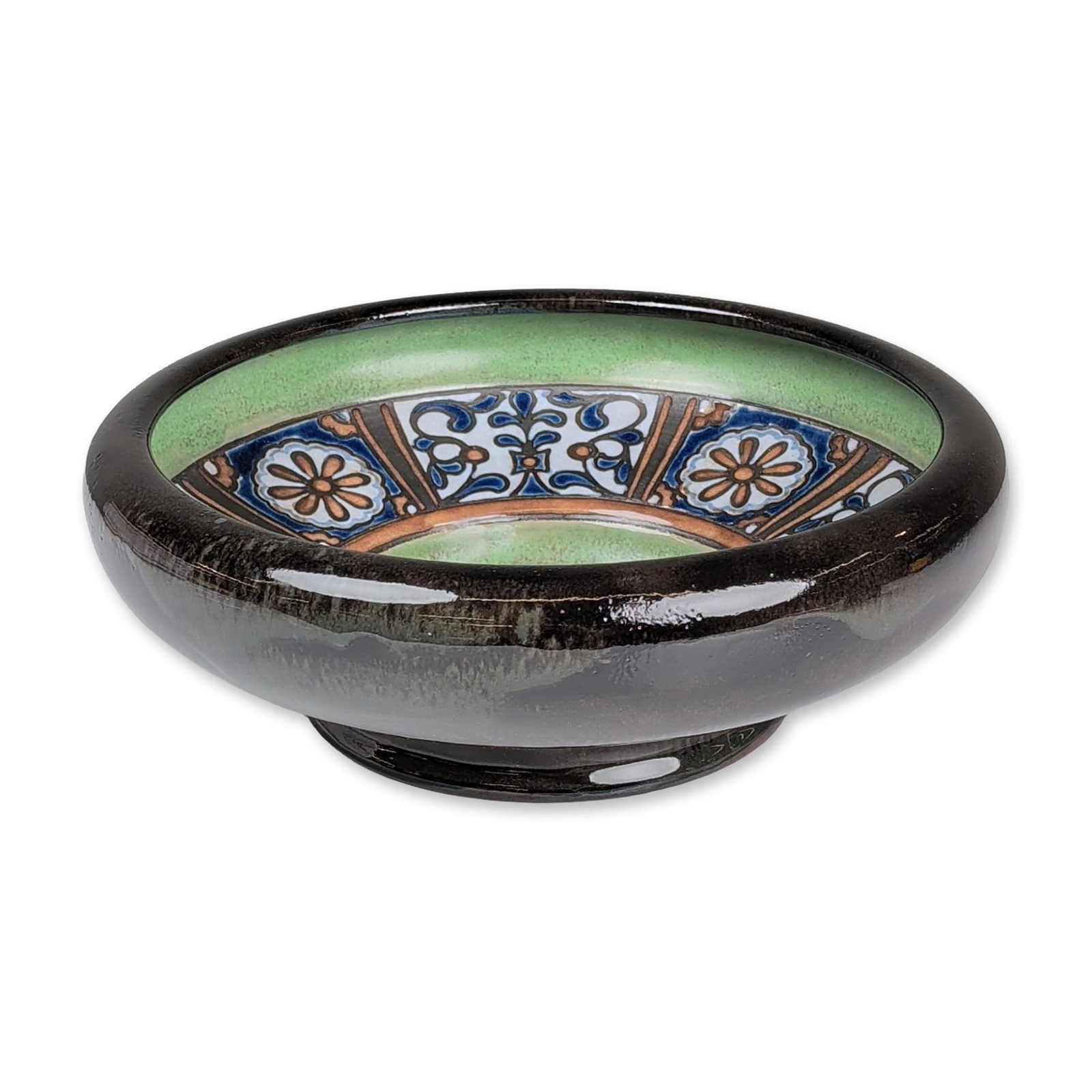 Royal Doulton by Mark V. Marshall Stoneware Bird Motif Bowl: A stoneware footed bowl decorated by artist Mark V. Marshall. The interior features a central medallion depicting a white bird against a cobalt blue ground, encircled by a broad sage green band. The o